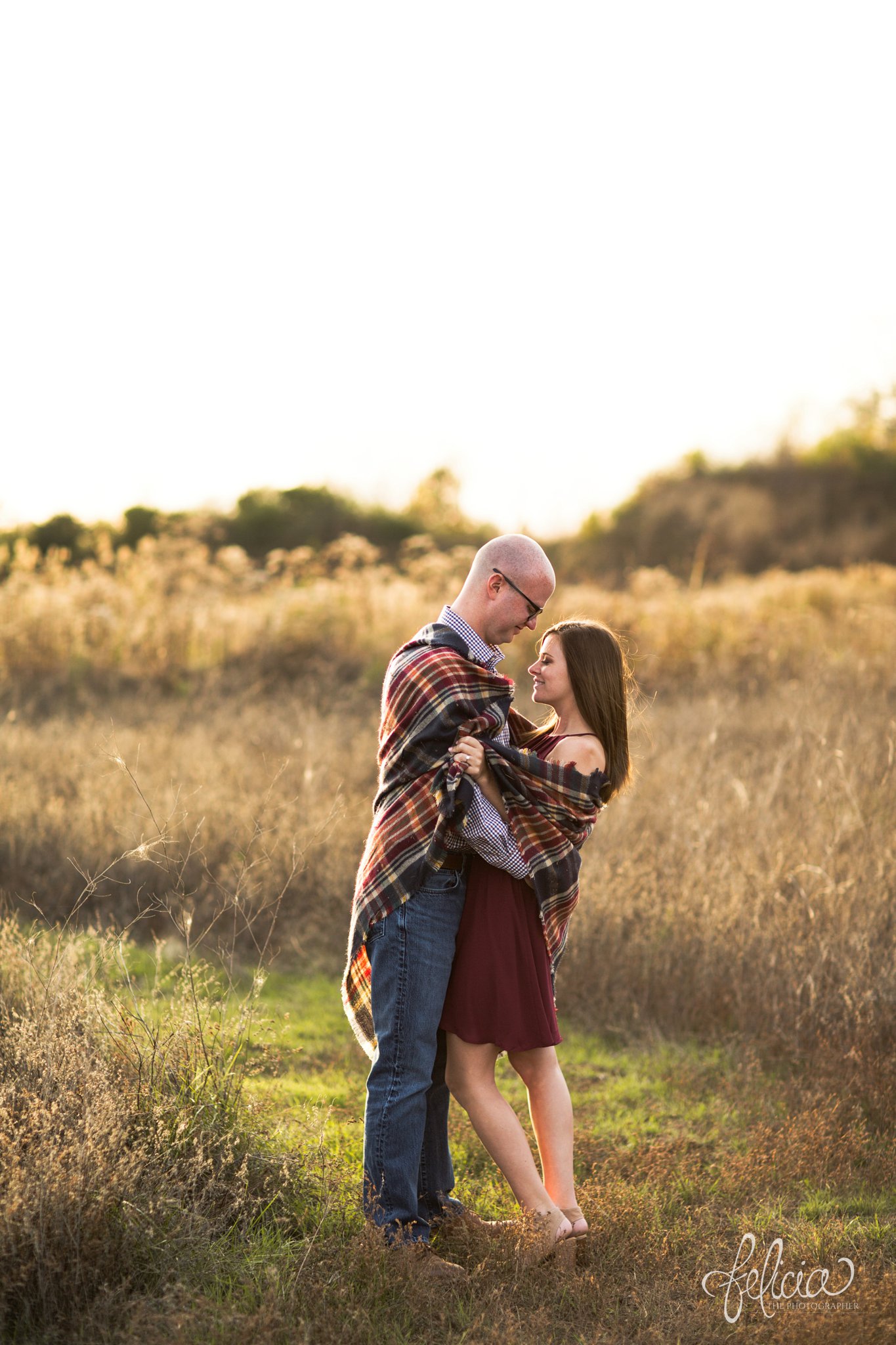 engagement pictures | engagement photos | nature | golden hour | sunset | sunset photography | fall | autumn | burgundy | picnic | picnic blanket | hug | plaid | romantic pose 