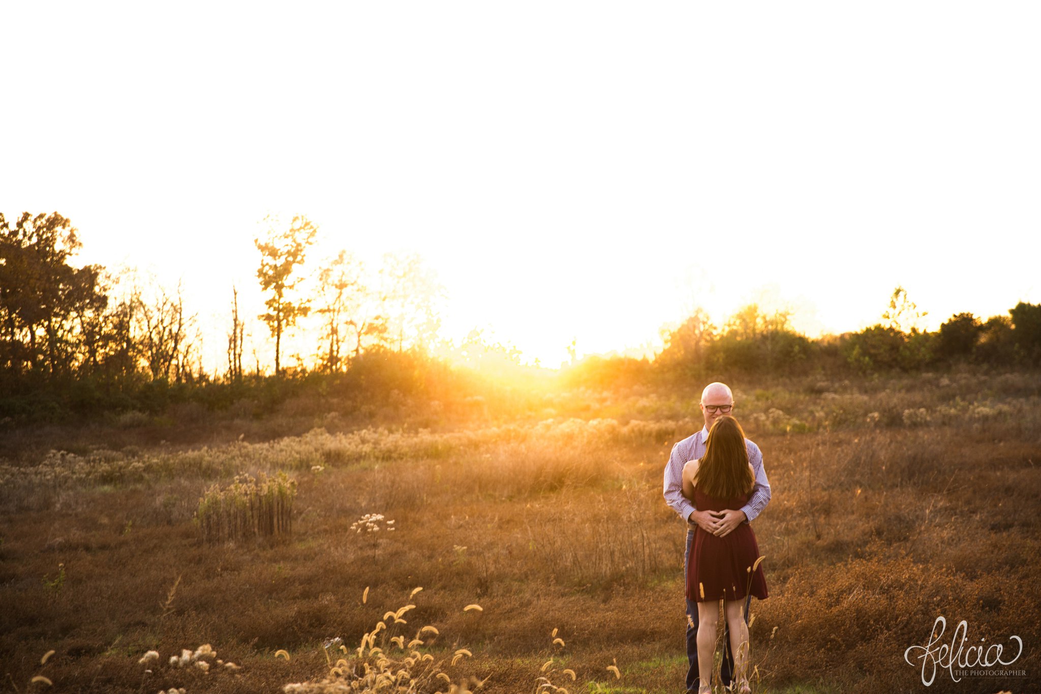 engagement pictures | engagement photos | nature | golden hour | sunset | sunset photography | fall | autumn | burgundy | natural | sun flare | expansive background | nature background | hugging | dance pose 