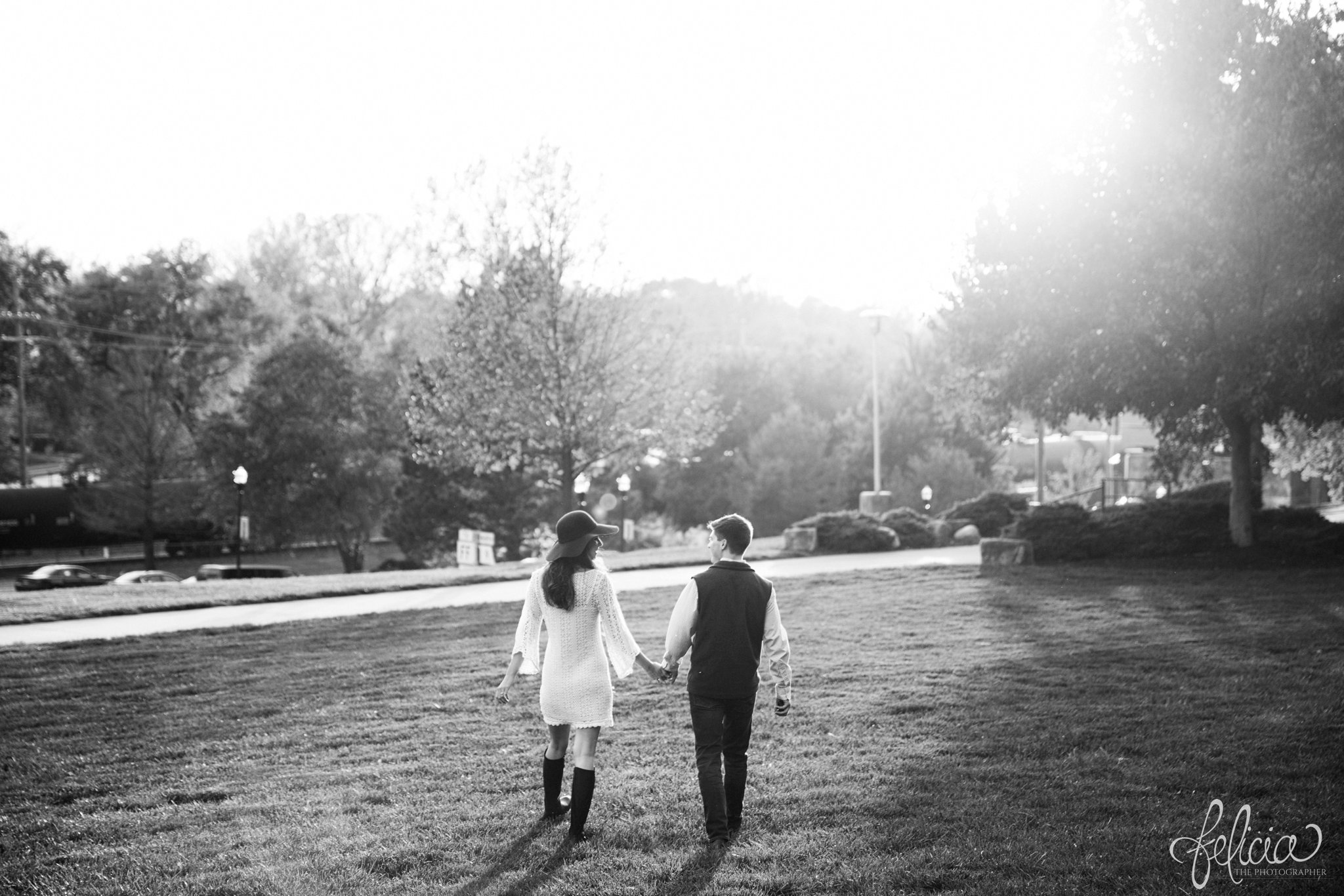 Black and White | Engagement Photos | Engagement Photography | Sunset | Sunset Photography | Felicia the Photographer | Images by feliciathephotographer.com | Fall | Autumn | Lake | Sun Flare | Holding Hands | Floppy Hat | Walking in Field | Back to Camera 