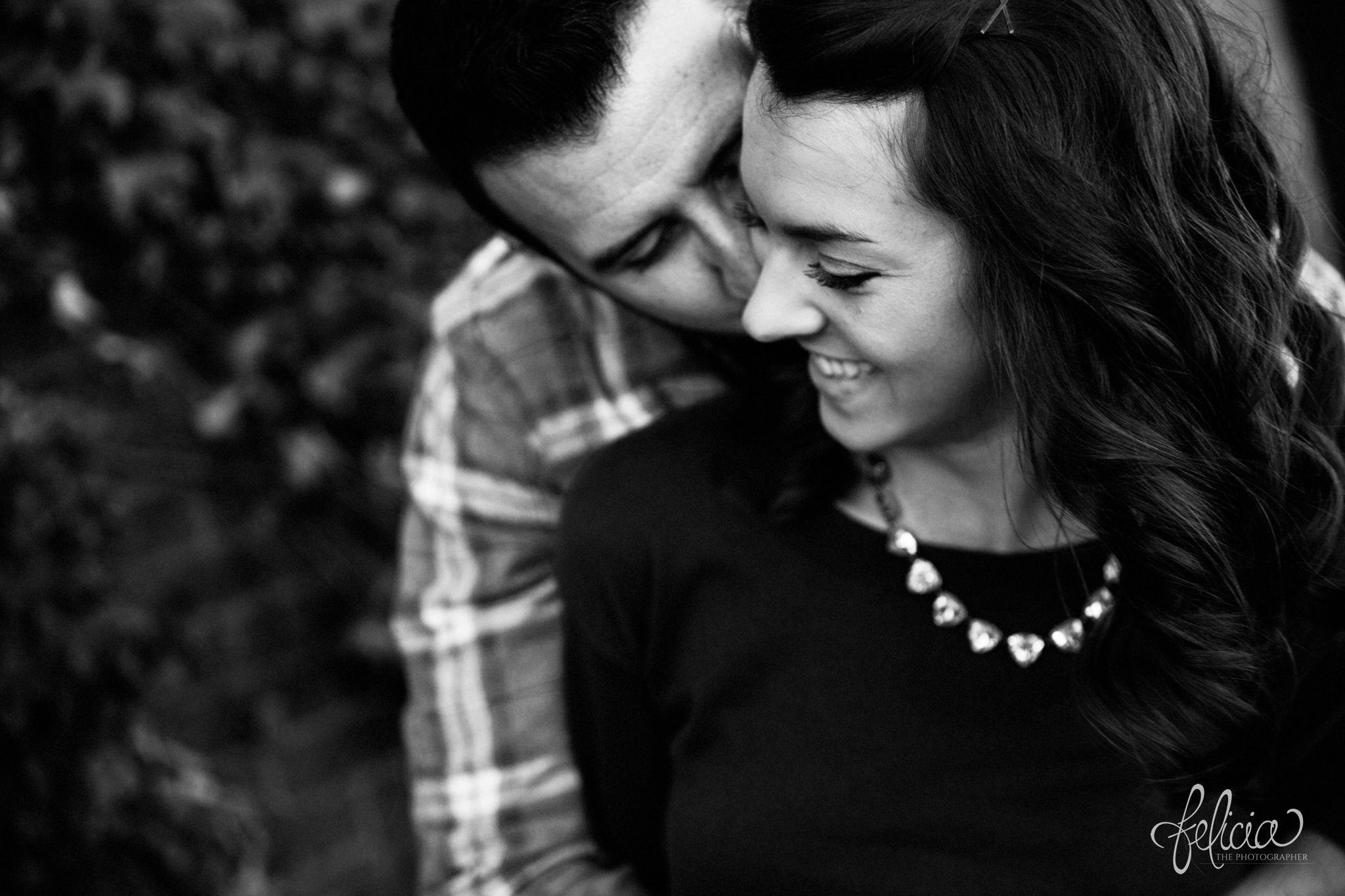 black and white | engagement photos | engagement photography | Kansas City | West Bottoms | images by feliciathephotographer.com | urban setting | industrial background | candid | smiling bride to be | kiss on cheek | cuddle | sitting 