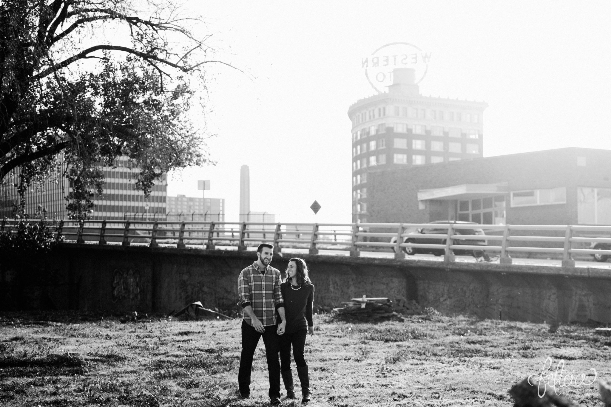 images by feliciathephotographer.com | black and white | engagement photos | engagement photography | Kansas City | West Bottoms | images by feliciathephotographer.com | urban setting | industrial background | sun flare | Western Auto sign | downtown | holding hands 