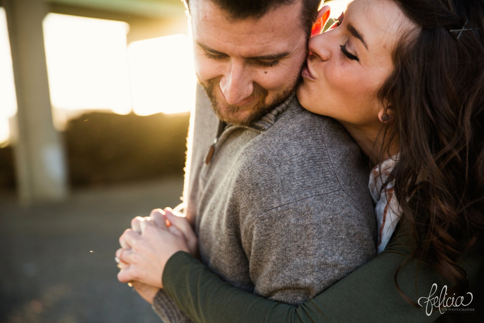 engagement photos | engagement photography | Kansas City | West Bottoms | images by feliciathephotographer.com | urban setting | industrial background | sun flare | romantic pose | kiss on cheek | holding hands | bridge background | close up | head shot | smiles 