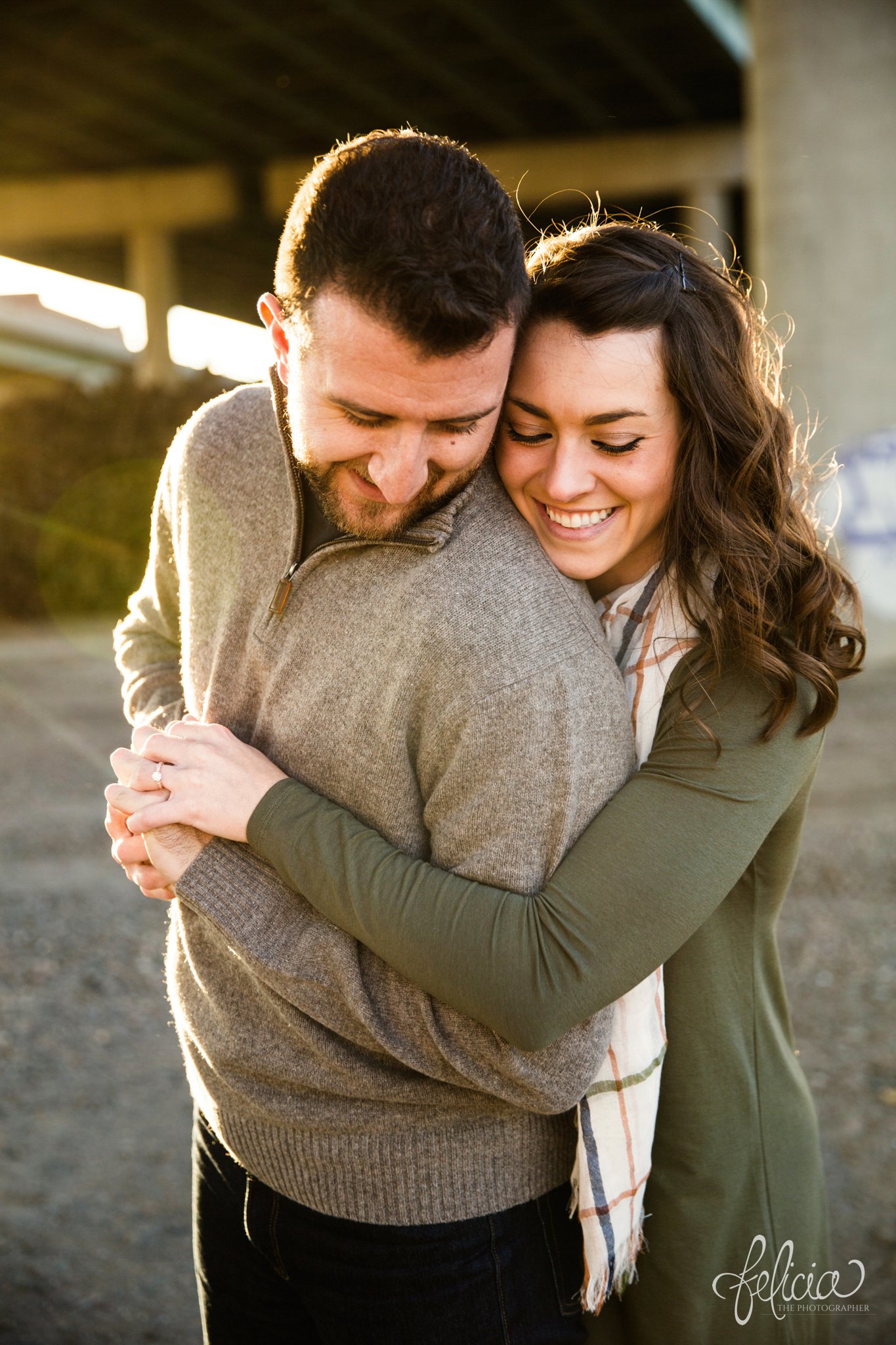 engagement photos | engagement photography | Kansas City | West Bottoms | images by feliciathephotographer.com | urban setting | industrial background | sun flare | romantic pose | candid | smiling bride | bride to be | sunset | holding hands | bridge background | downtown background | cuddling | fall colors | fall wardrobe 