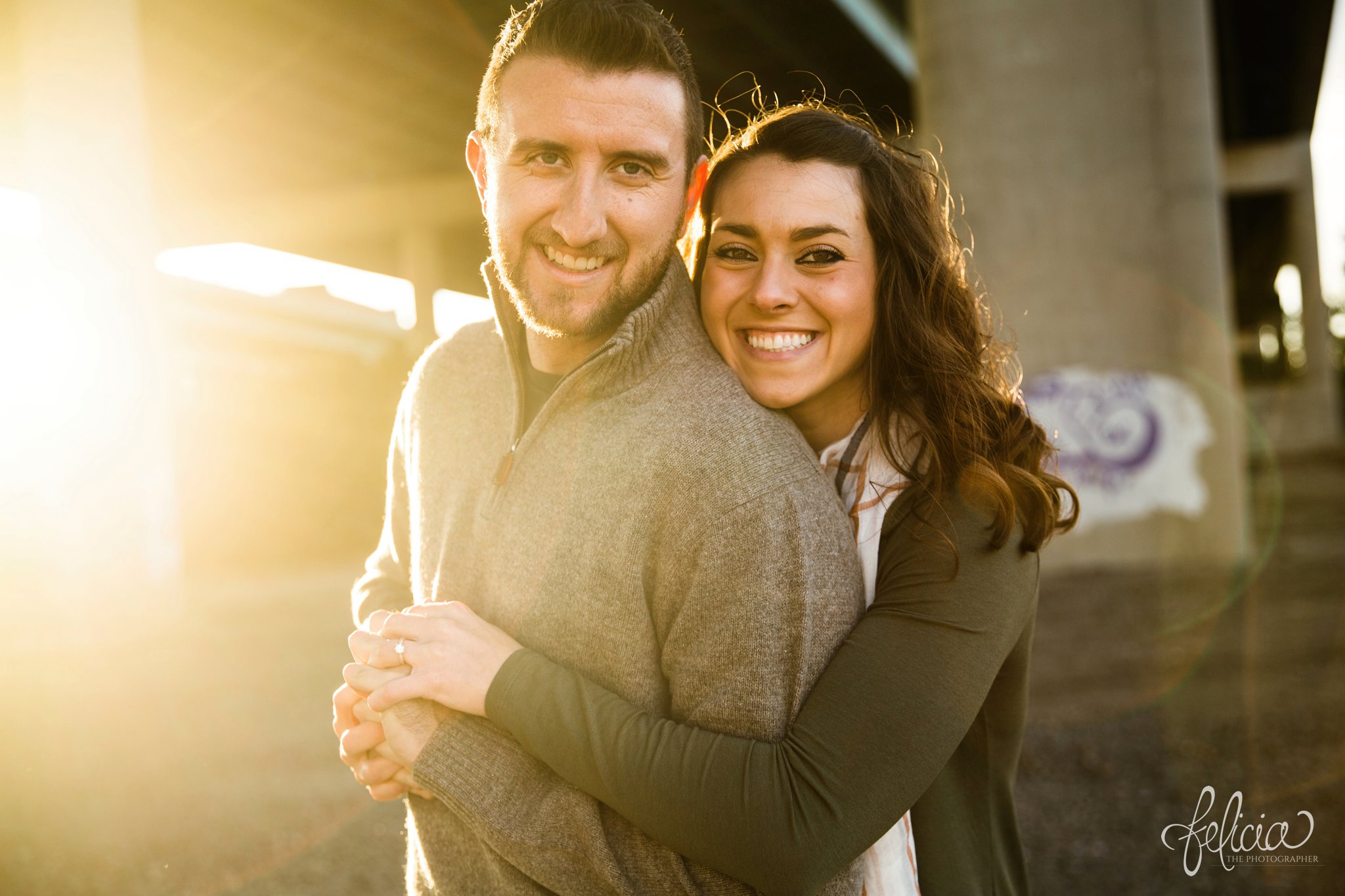 engagement photos | engagement photography | Kansas City | West Bottoms | images by feliciathephotographer.com | urban setting | industrial background | sun flare | romantic pose | candid | smiling bride | bride to be | sunset | holding hands | bridge background | downtown background | cuddling | fall colors | fall outfits | engagement shoot 