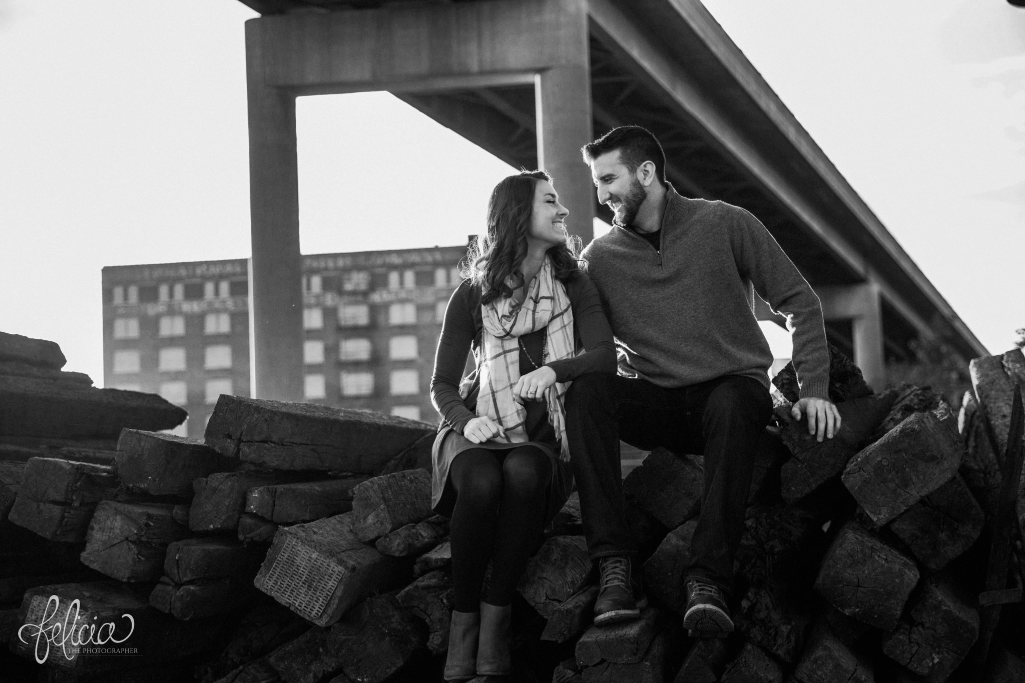 black and white | engagement photos | engagement photography | Kansas City | West Bottoms | images by feliciathephotographer.com | urban setting | industrial background | engagement shoot | wood background | overpass | eye contact 