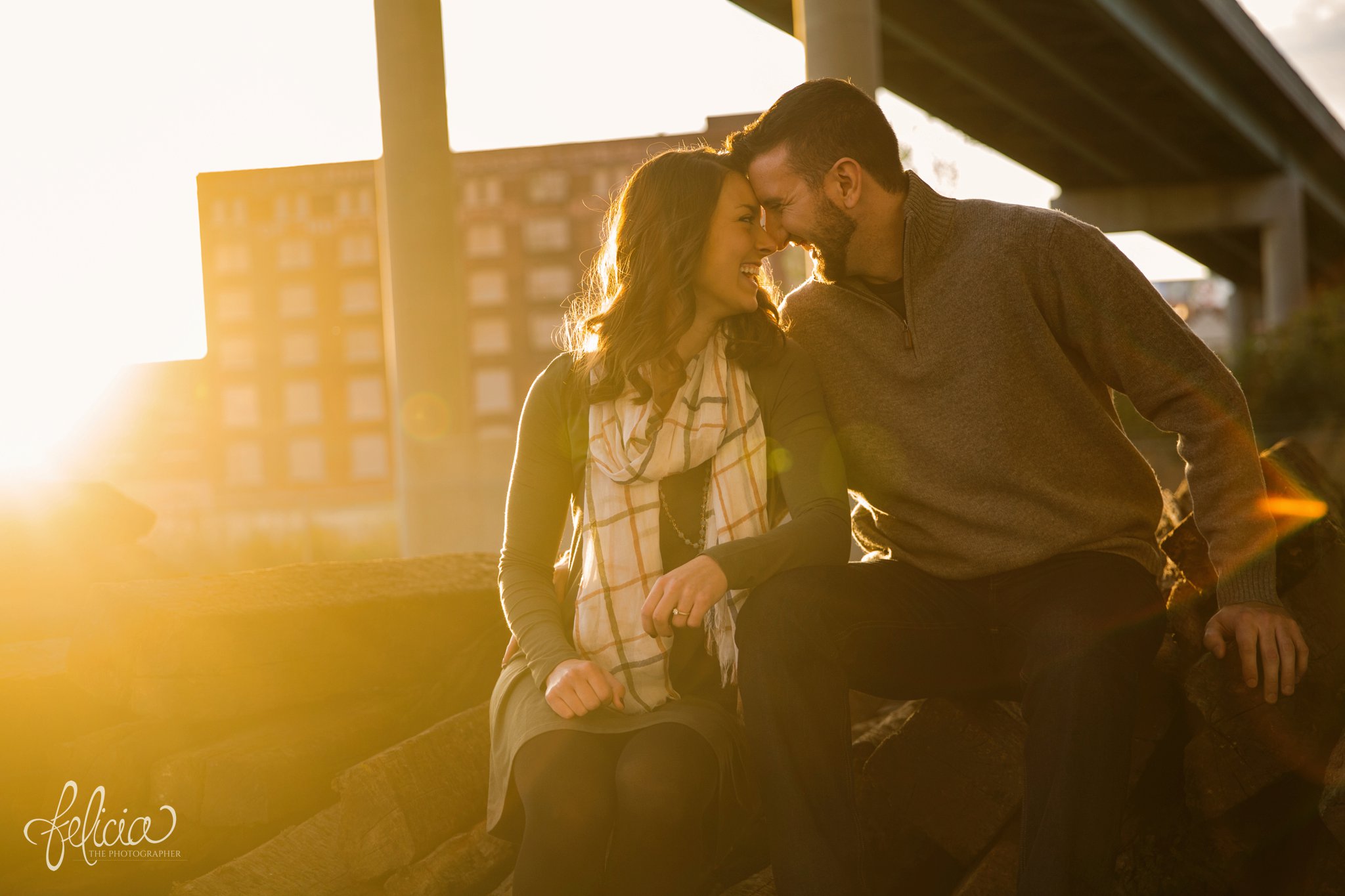 engagement photos | engagement photography | Kansas City | West Bottoms | images by feliciathephotographer.com | urban setting | industrial background | engagement shoot | sun flare | candid | laughter | forehead touch | overpass 