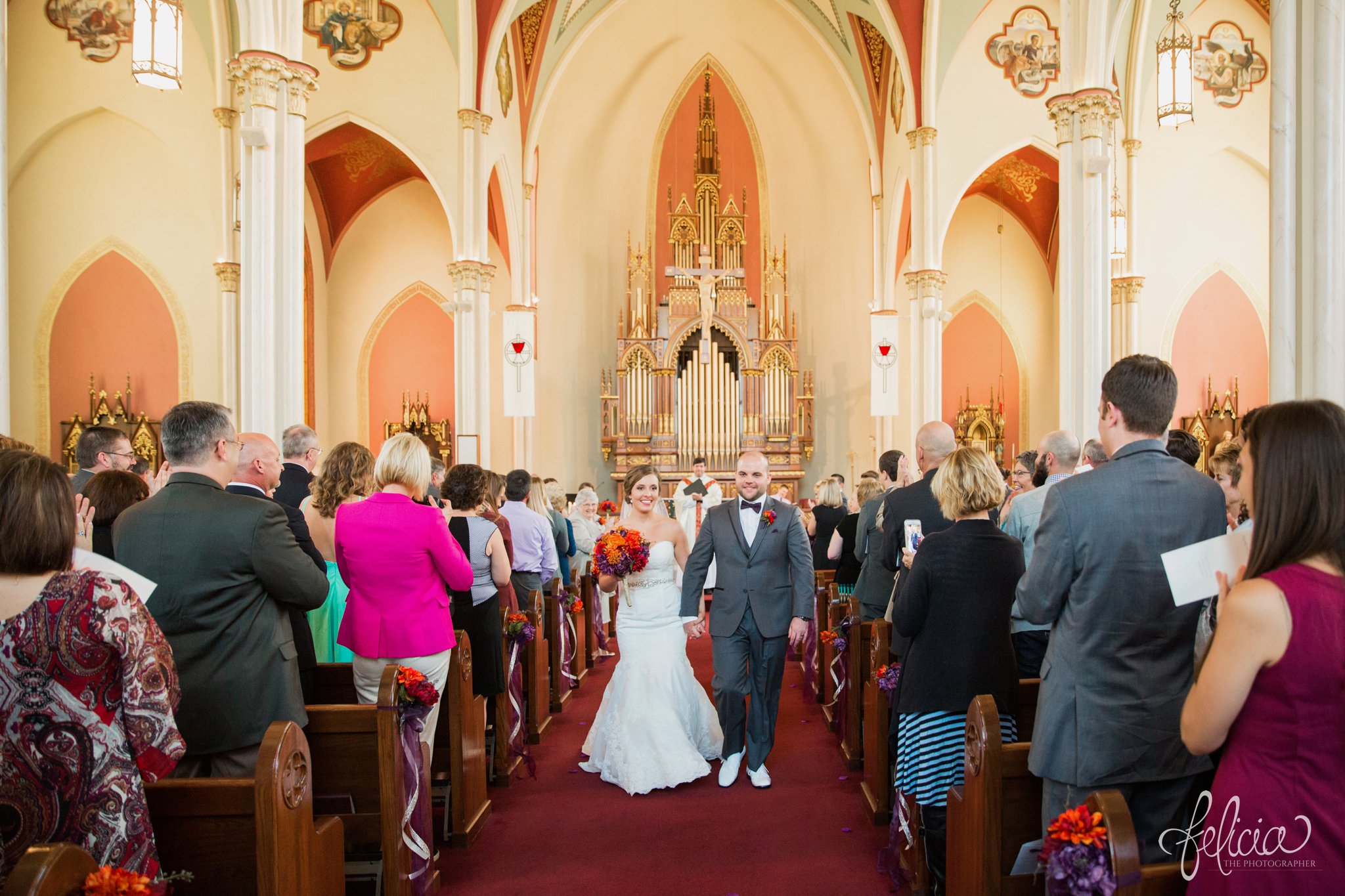 weddings | wedding photography | wedding photos | images by feliciathephotographer.com | St. Francis Xavier Church | Moila Country Club | autumn wedding | fall wedding | fall colors | harvest | purple and orange | Kansas City | St. Joseph | harvest inspiration | wedding ceremony | church exit | bride and groom | walking down the aisle | man and wife | vaulted ceilings 