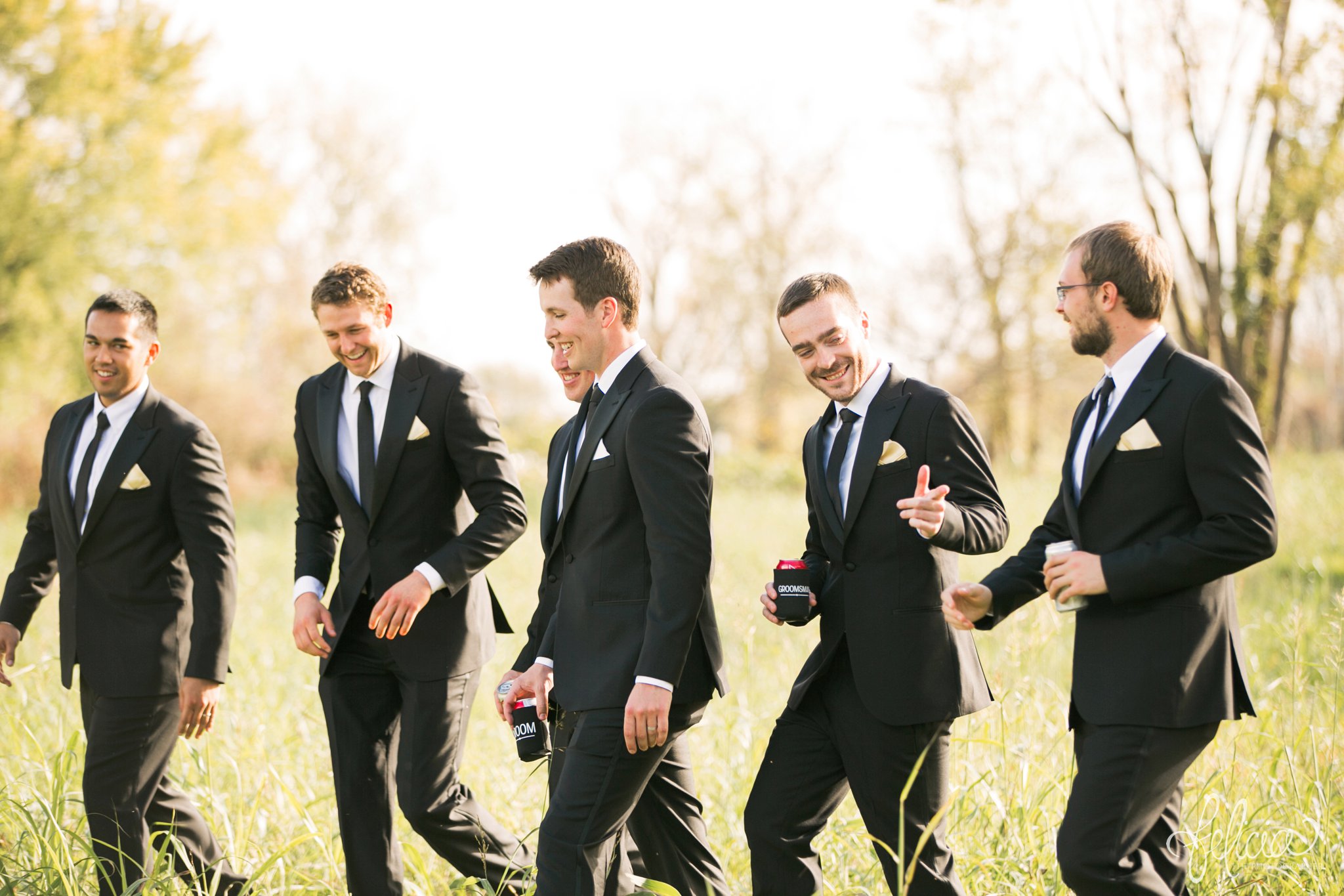 weddings | wedding photos | wedding photography | images by feliciathephotographer.com | St. Therese Catholic Church | Kansas City | downtown | The Terrace on Grand | bridal party portraits | grassy field | field | nature | candid | groomsmen portrait | laughing | walking | jokes | funny groomsmen | The Black Tux 