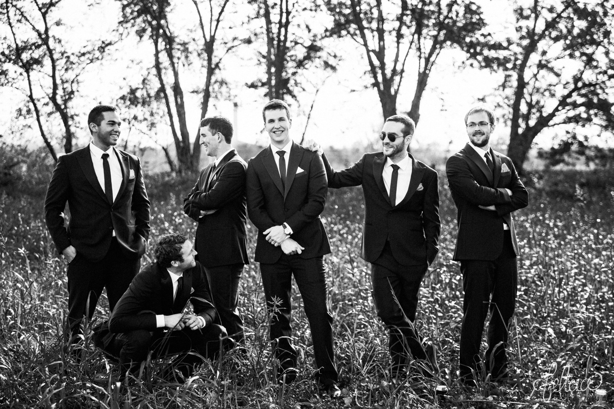 black and white | weddings | wedding photos | wedding photography | images by feliciathephotographer.com | St. Therese Catholic Church | Kansas City | downtown | The Terrace on Grand | bridal party portraits | grassy field | field | nature | candid | groomsmen portrait | casual poses | funny groomsmen | The Black Tux
