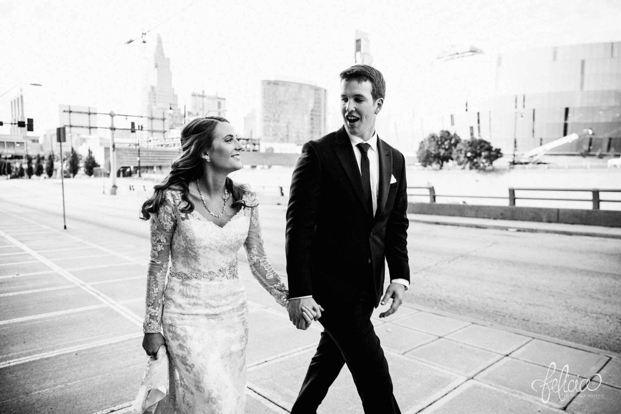 black and white | weddings | wedding photos | wedding photography | images by feliciathephotographer.com | St. Therese Catholic Church | Kansas City | downtown | The Terrace on Grand | bridal party portraits | urban jungle | downtown skyline | candid | holding hands | street photography | crosswalk 