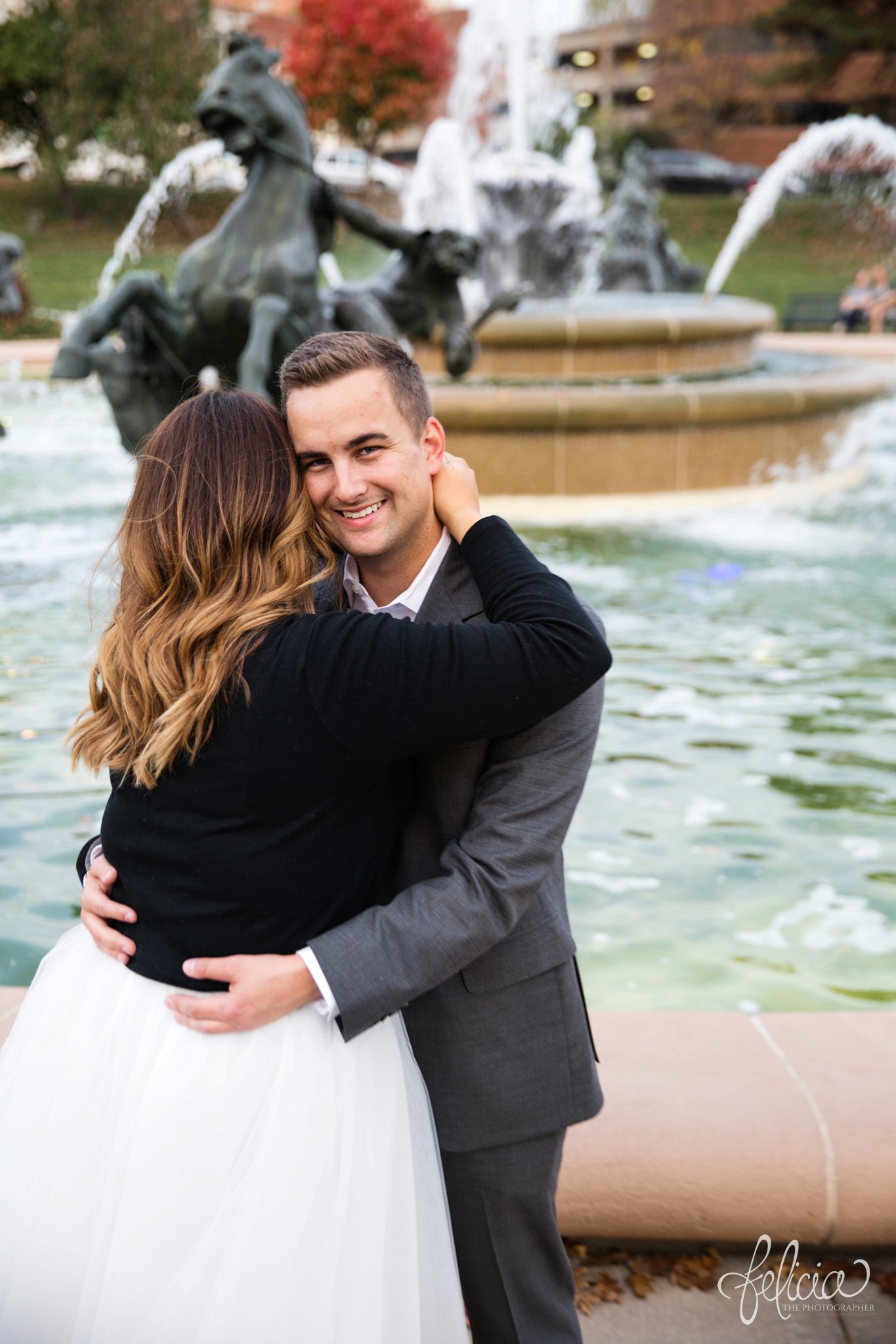 engagement photos | engagement photography | Kansas City | images by feliciathephotographer.com | architectural backgrounds | downtown | downtown Kansas City | fountain | Plaza Country Club | romantic pose | cuddling | smiling groom 