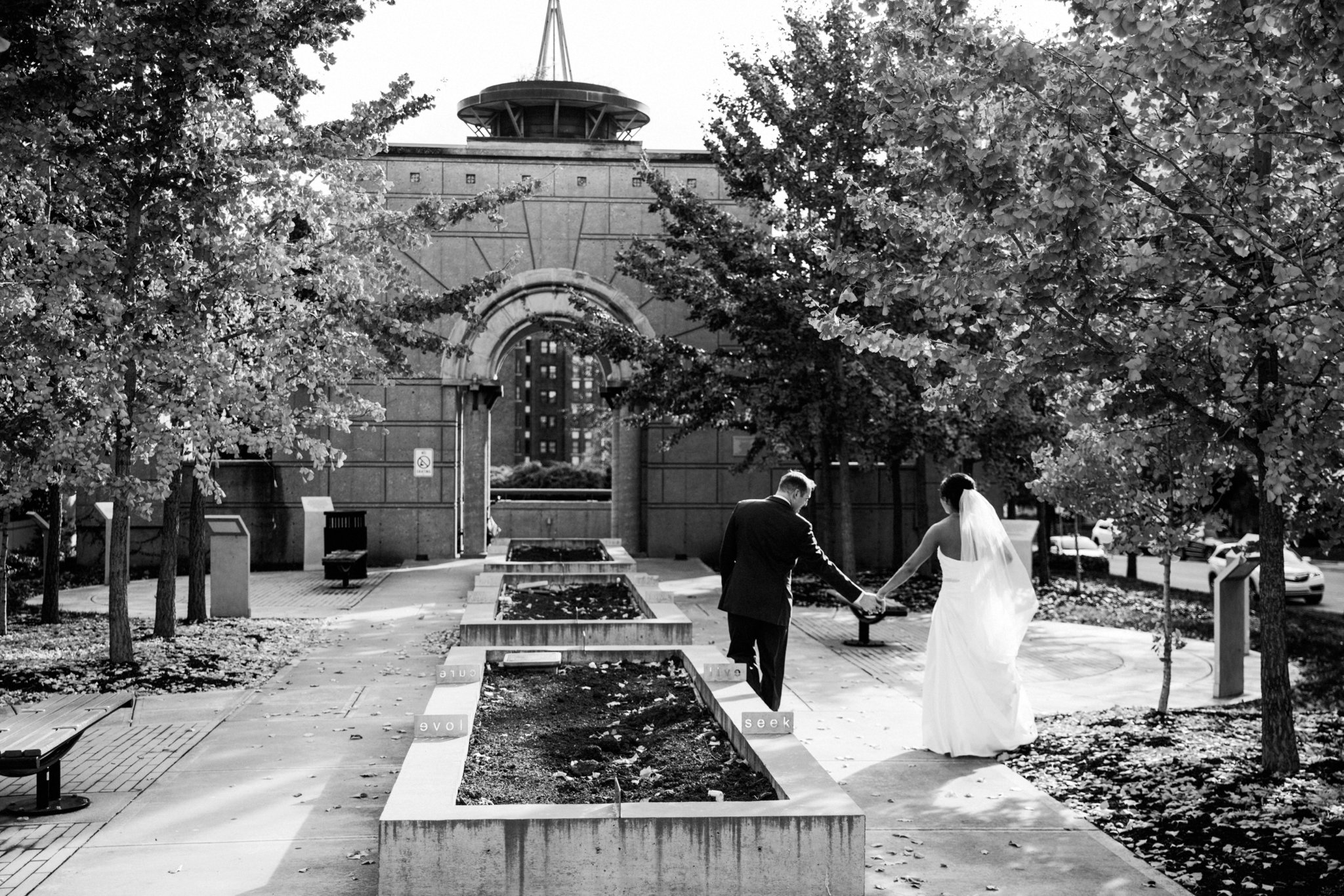 black and white | wedding | wedding photos | wedding photography | images by feliciathephotographer.com | Country Club Plaza | Kansas City | Unity Temple | Cancer Survivor Park | bride and groom portraits | candid | walking through park | hand holding