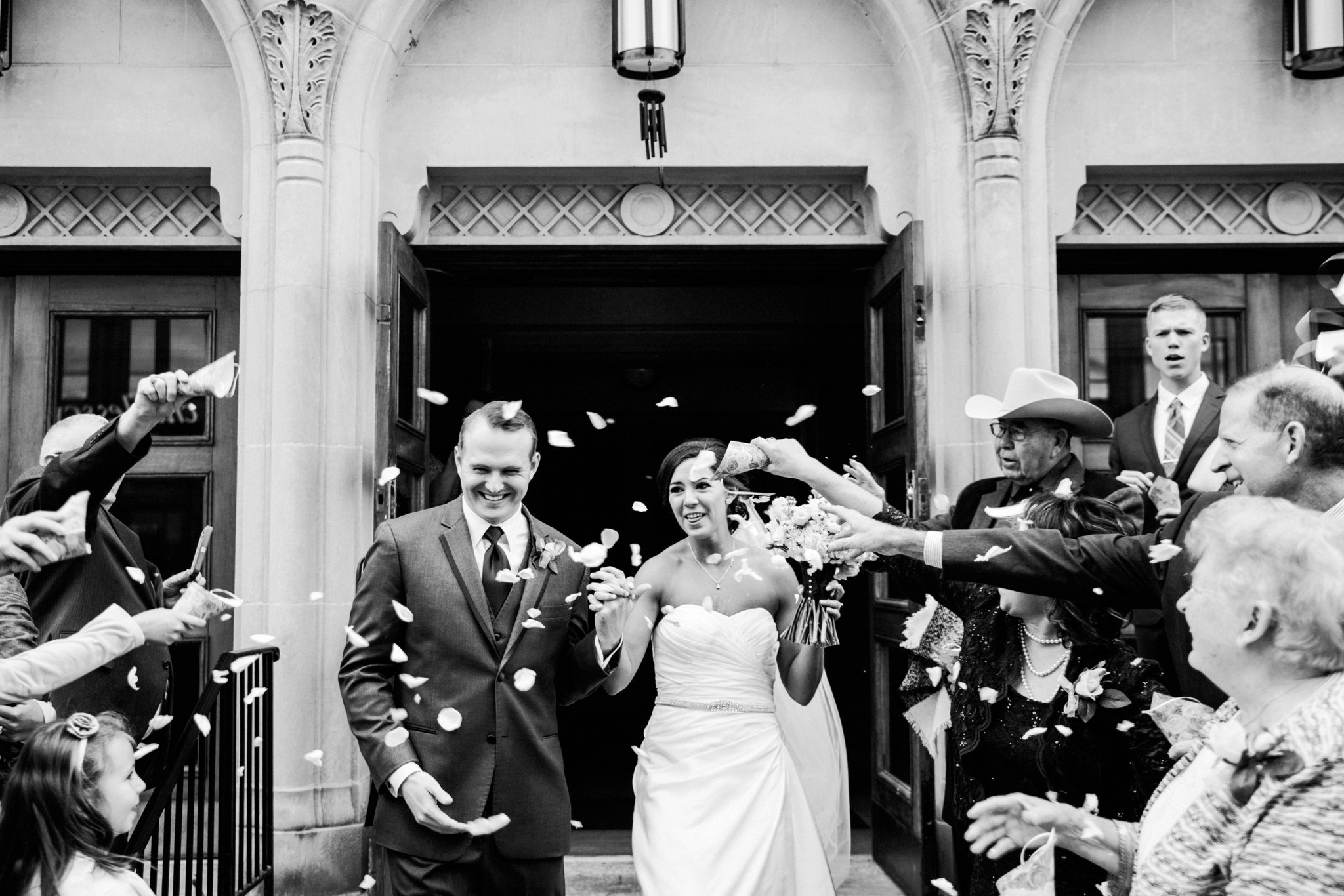 black and white | wedding | wedding photos | wedding photography | images by feliciathephotographer.com | Country Club Plaza | Kansas City | Unity Temple | wedding ceremony | man and wife | church exit | flower petals | confetti | celebration | candid 