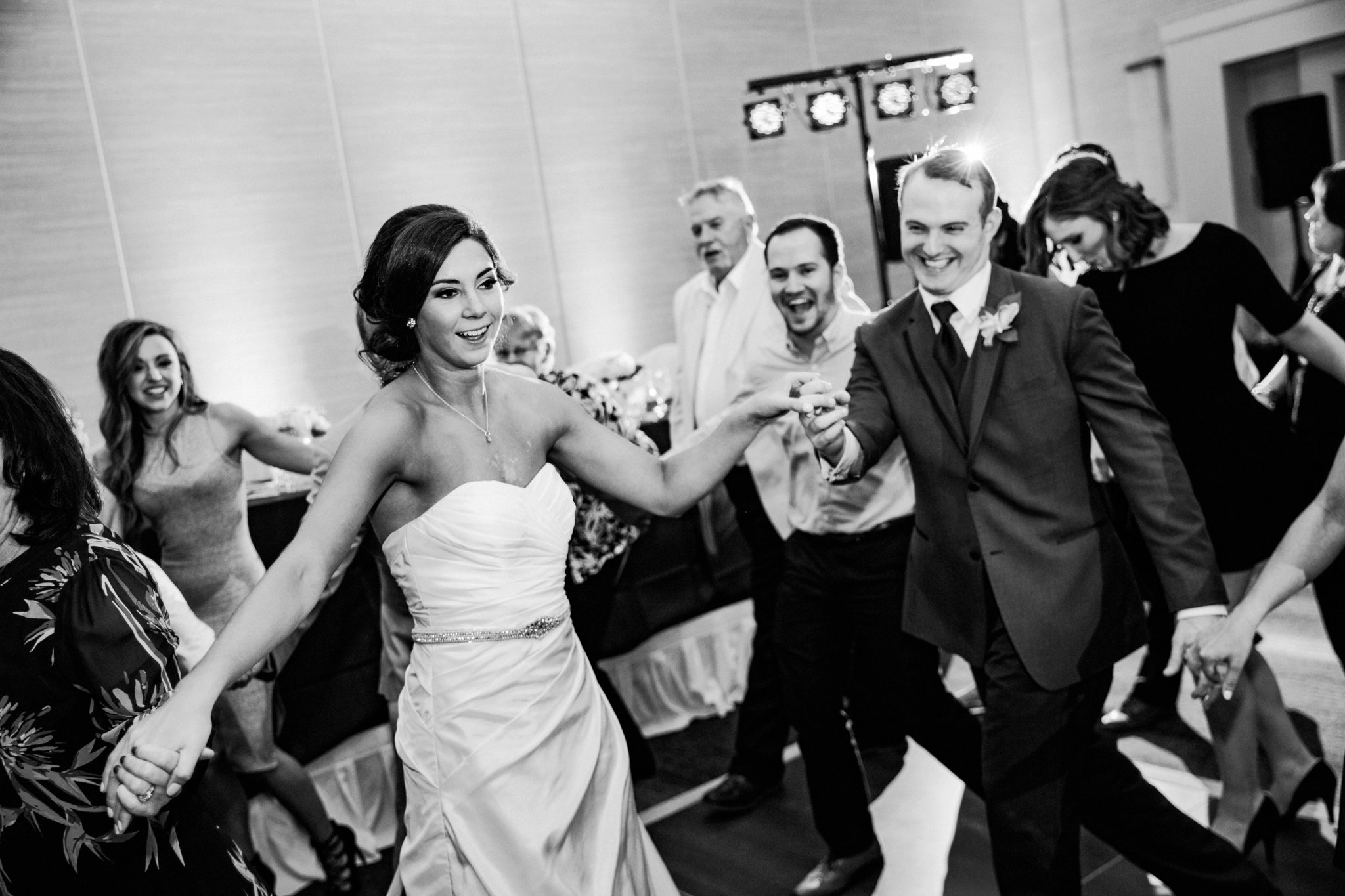 black and white | wedding | wedding photos | wedding photography | images by feliciathephotographer.com | Country Club Plaza | Kansas City | The Marriott | Unity Temple | reception venue | reception activities | dance floor | candid | guests dancing | Jukeboxx Media | dancing bride | spot lights | smiling groom 