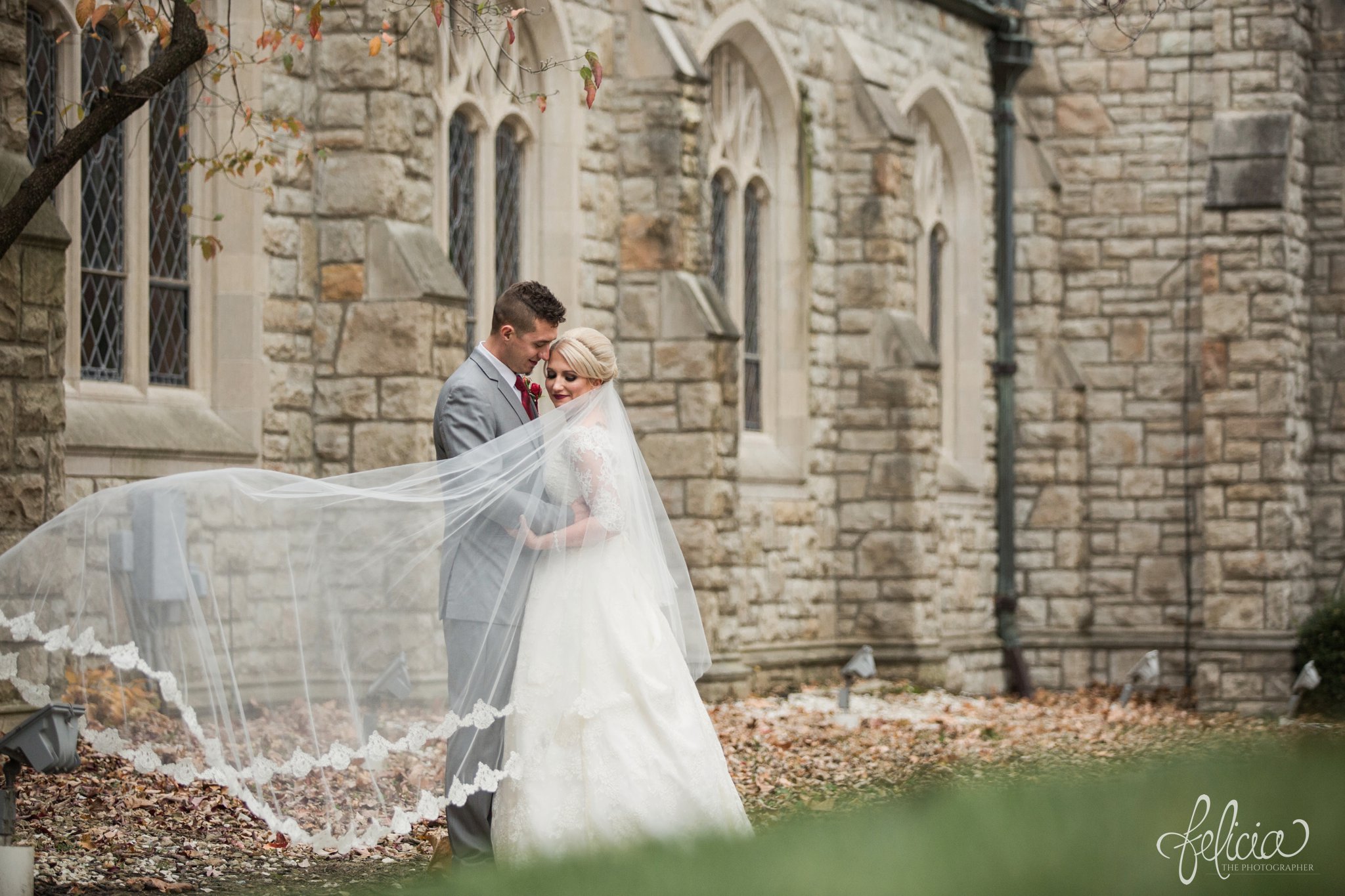 wedding | wedding photography | wedding photos | Kansas City | St. Patrick's Catholic Church | Hawthorne House | images by feliciathephotographer.com | crimson wedding | Christmas Wedding | winter portraits | dramatic veil | lace sleeves | lace wedding dress | Paula Varsalona | bride and groom | church background | stone background | romantic pose | flowing veil 