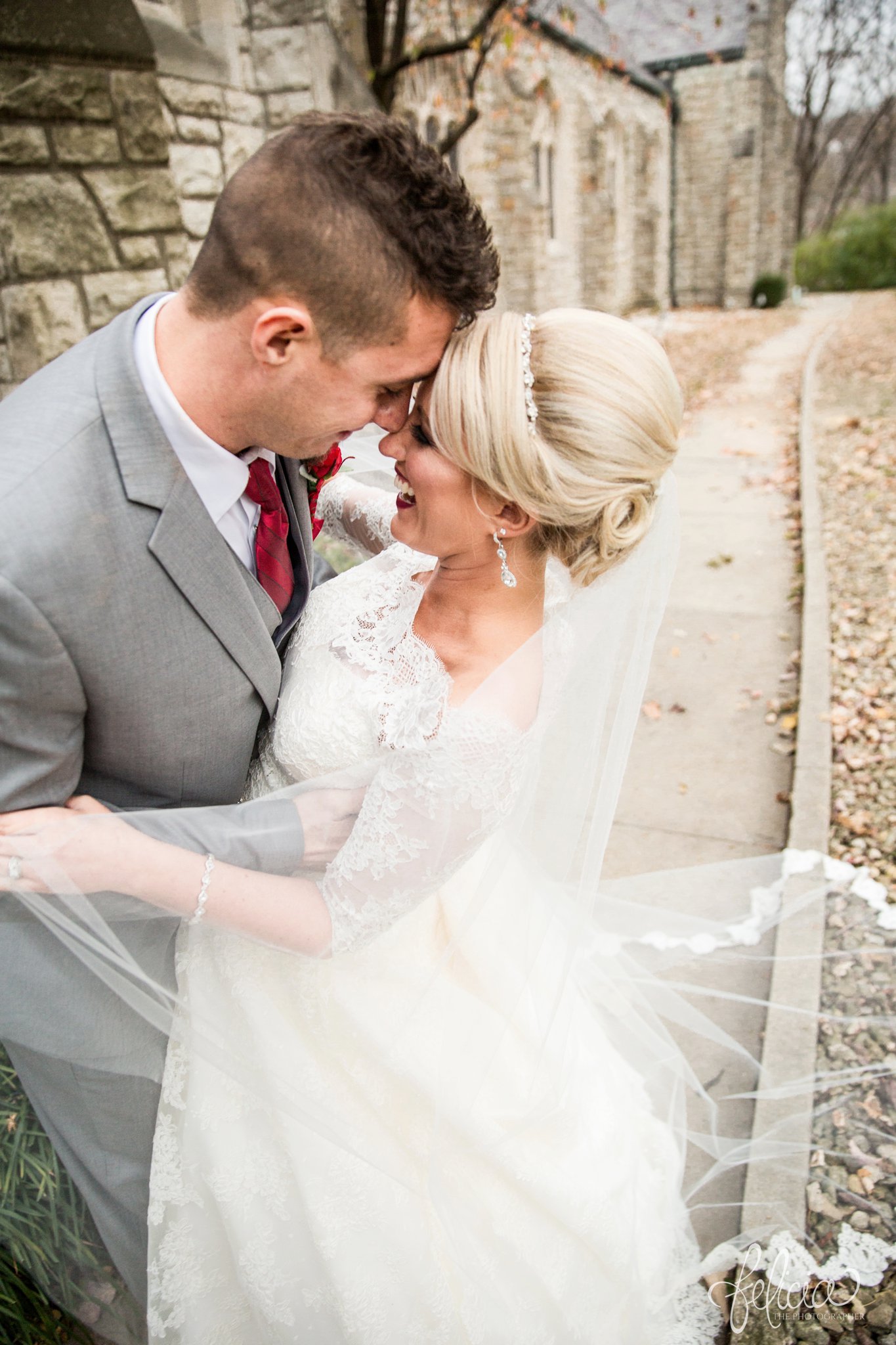 wedding | wedding photography | wedding photos | Kansas City | St. Patrick's Catholic Church | Hawthorne House | images by feliciathephotographer.com | crimson wedding | Christmas Wedding | winter portraits | dramatic veil | lace sleeves | lace wedding dress | Paula Varsalona | bride and groom | church background | stone background | romantic pose | flowing veil | forehead touching | candid | laughing bride 