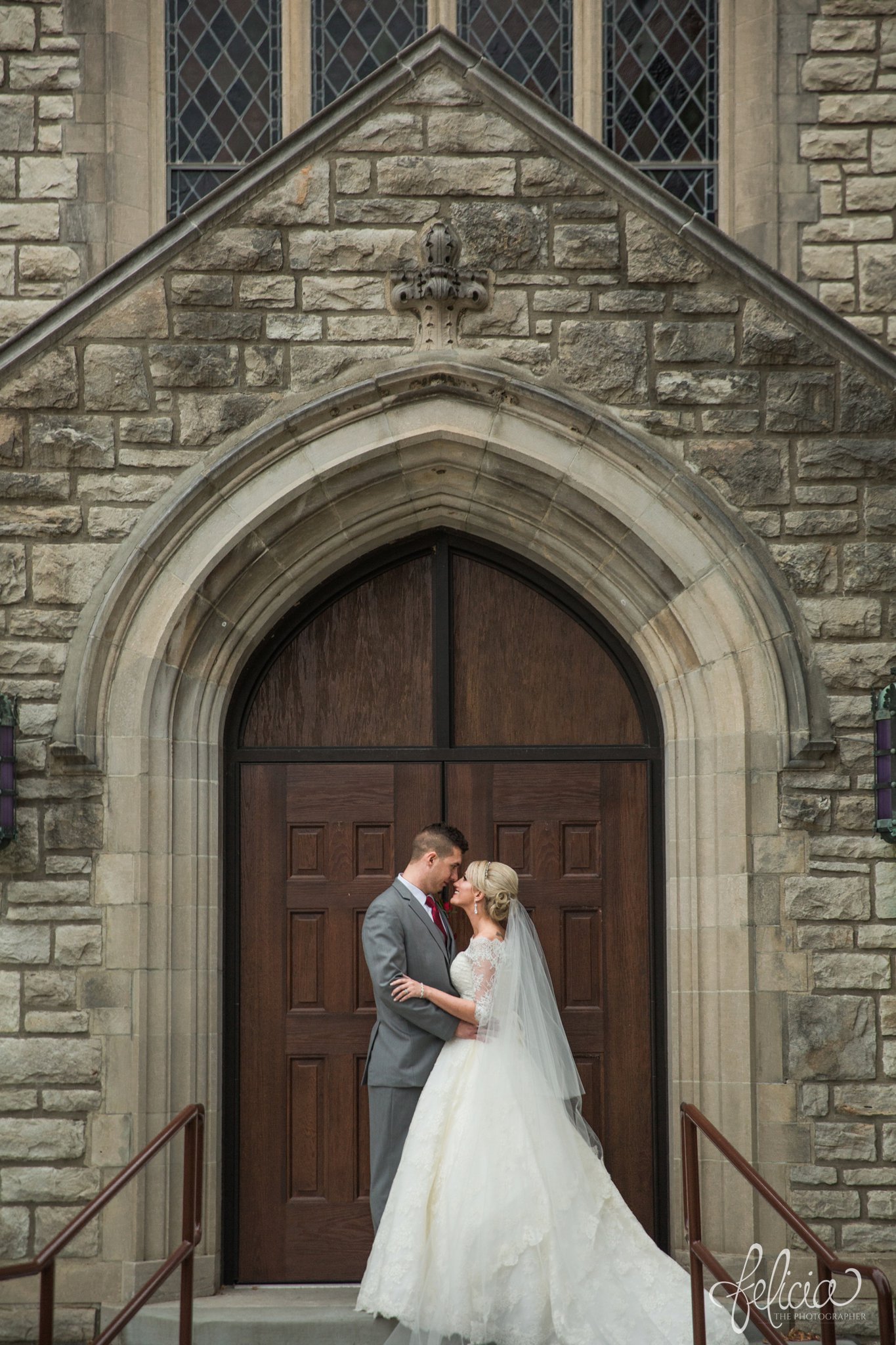 wedding | wedding photography | wedding photos | Kansas City | St. Patrick's Catholic Church | Hawthorne House | images by feliciathephotographer.com | crimson wedding | Christmas Wedding | winter portraits | dramatic veil | lace sleeves | lace wedding dress | Paula Varsalona | bride and groom | church background | stone background | romantic pose | stone arch | wooden door 