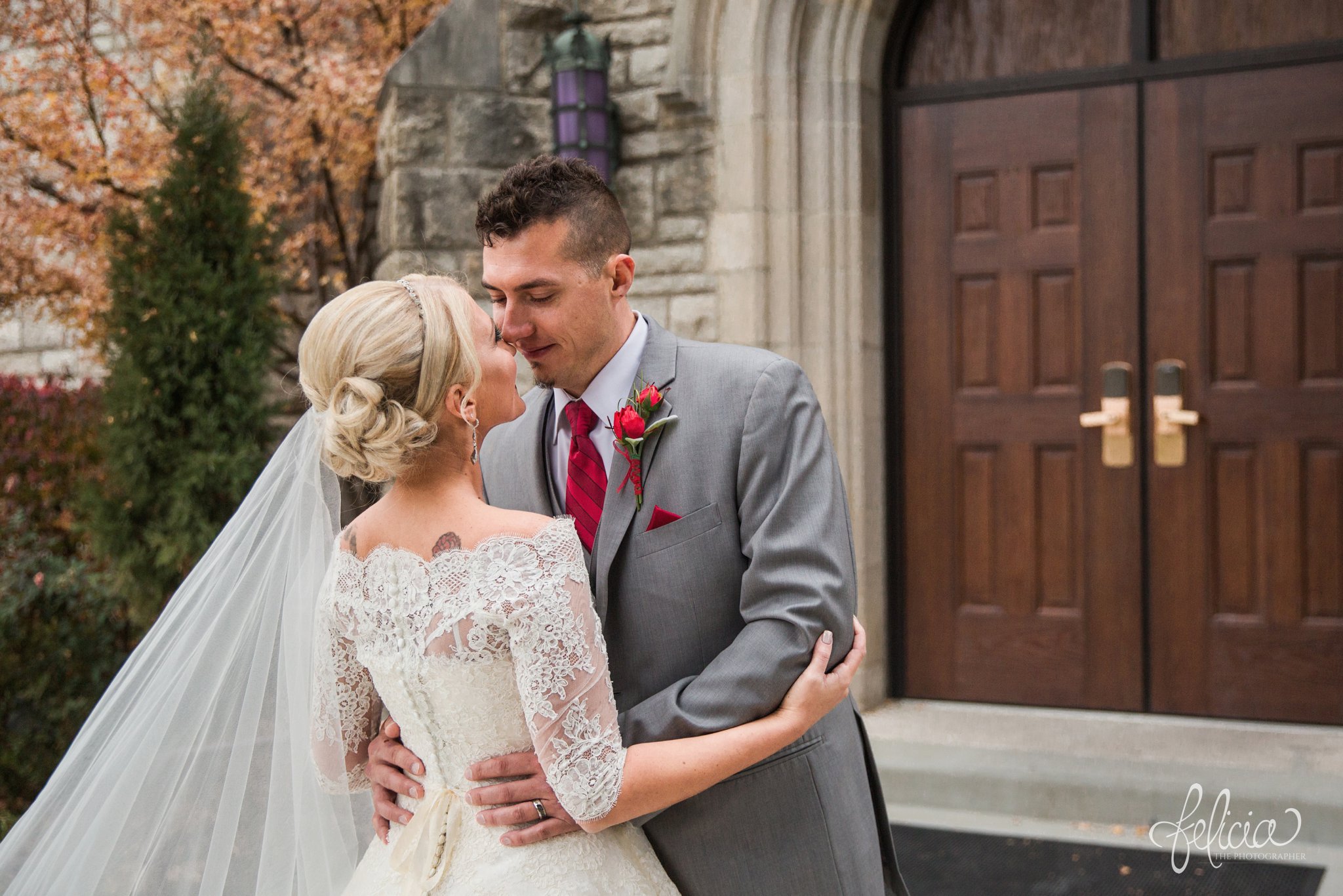 wedding | wedding photography | wedding photos | Kansas City | St. Patrick's Catholic Church | Hawthorne House | images by feliciathephotographer.com | crimson wedding | Christmas Wedding | winter portraits | dramatic veil | lace sleeves | lace wedding dress | Paula Varsalona | bride and groom | embrace | church doors | nose touch 