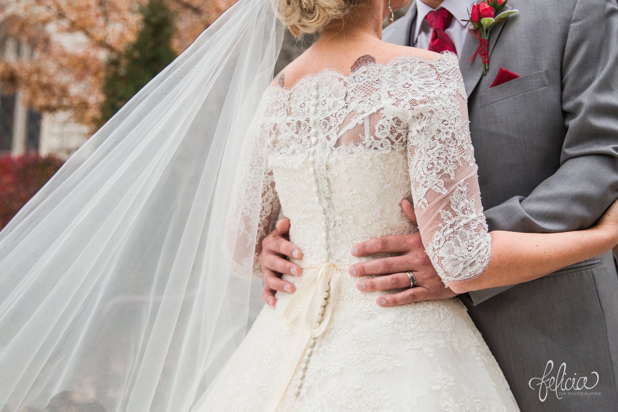 wedding | wedding photography | wedding photos | Kansas City | St. Patrick's Catholic Church | Hawthorne House | images by feliciathephotographer.com | crimson wedding | Christmas Wedding | winter portraits | dramatic veil | lace sleeves | lace wedding dress | Paula Varsalona | bride and groom | embrace | church doors | satin buttons | flowing veil | crimson tux accessories | hands on waist 