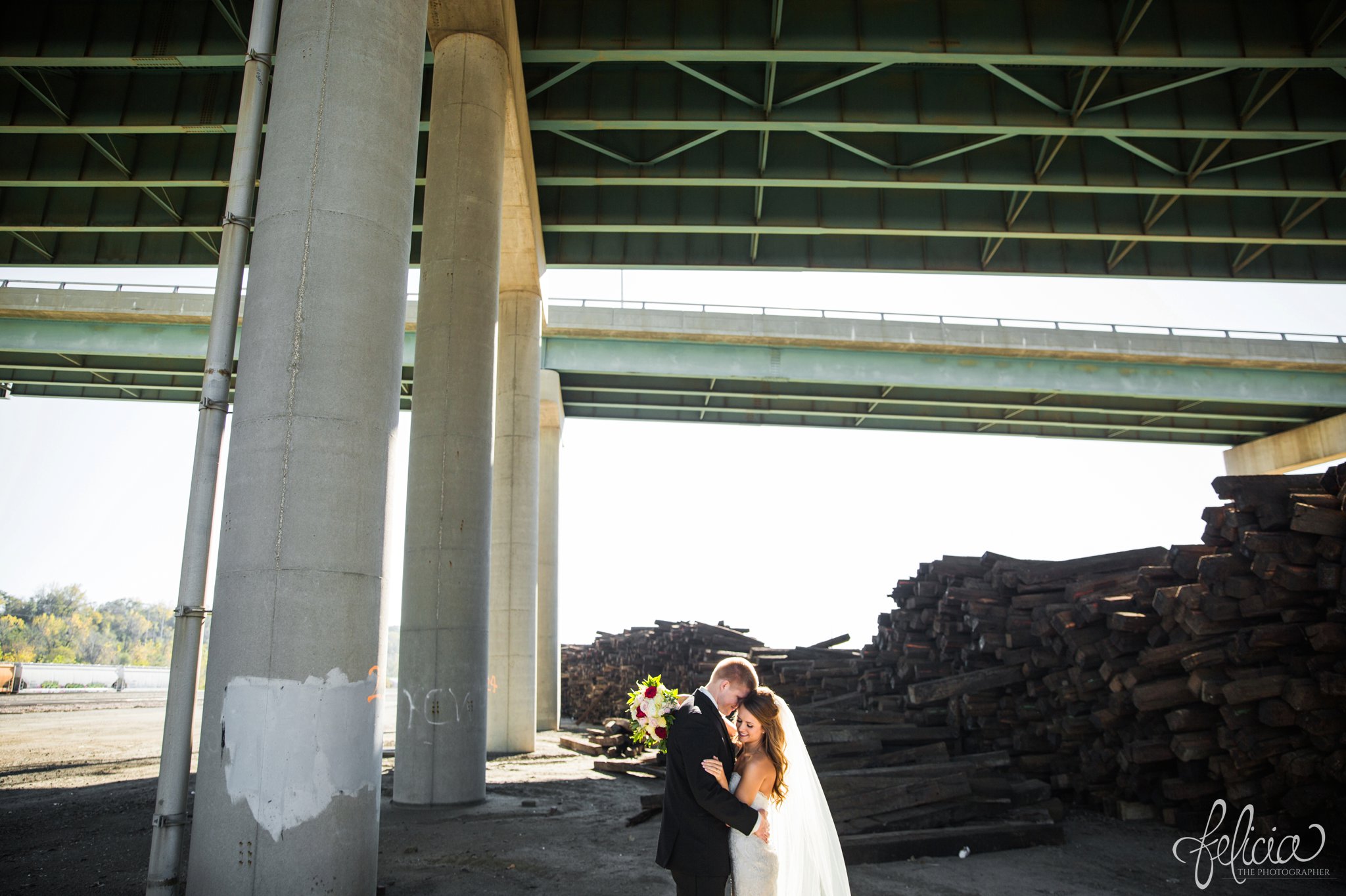 wedding | wedding photos | industrial | Rumely Event Space | wedding photography | images by feliciathephotographer.com | West Bottoms | industrial background | bride and groom portrait | overpass | embracing | bouquet over the shoulder 