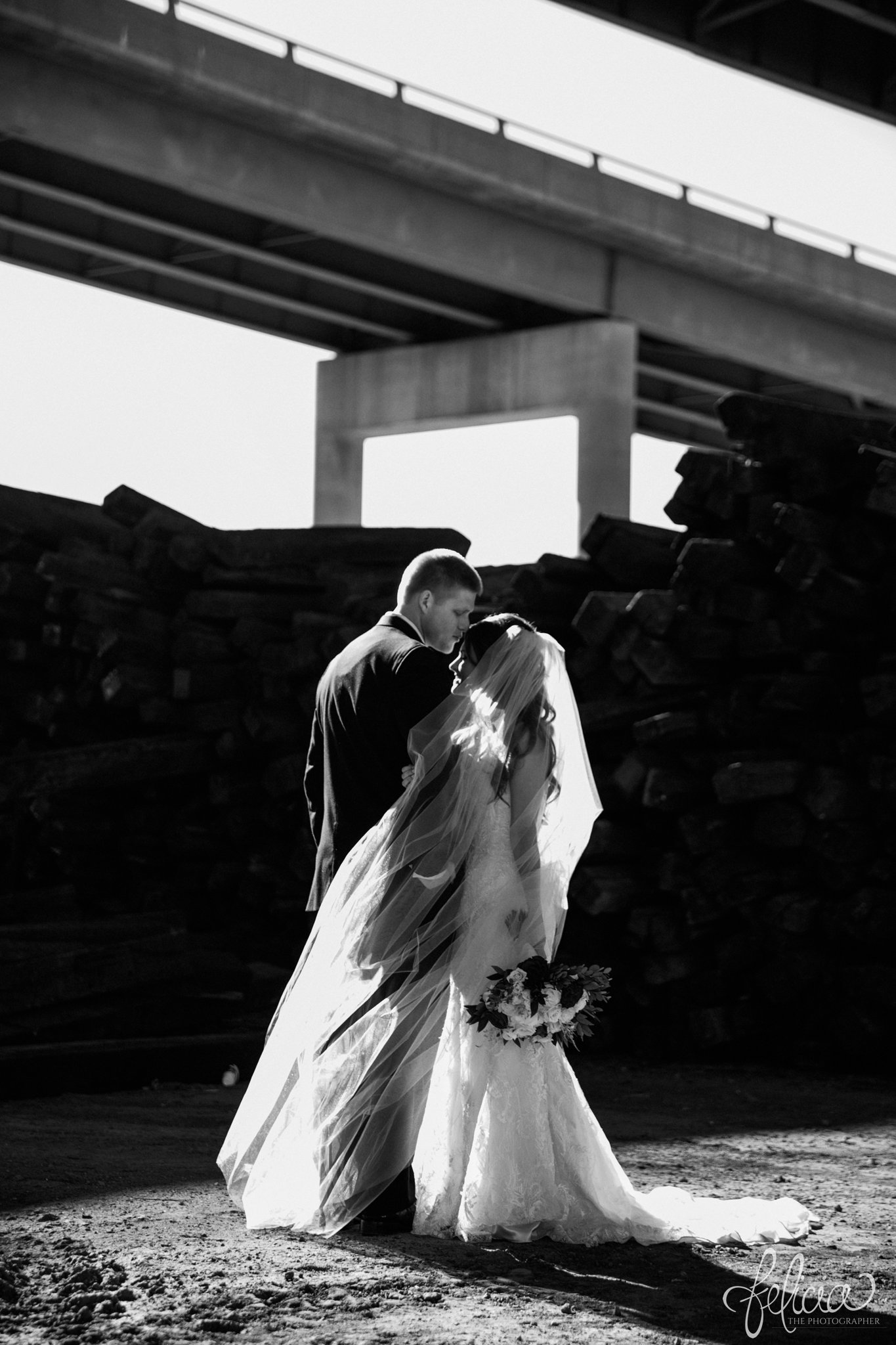 black and white | wedding | wedding photos | industrial | Rumely Event Space | wedding photography | images by feliciathephotographer.com | West Bottoms | industrial background | bride and groom portraits | forehead kiss | romantic pose | dramatic 