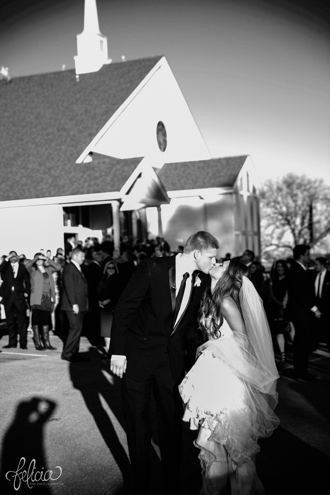black and white | wedding | wedding photos | industrial | Rumely Event Space | wedding photography | images by feliciathephotographer.com | West Bottoms | wedding ceremony | The Providence Baptist Church | bride and groom | Mr. and Mrs. | exiting the church | kissing outside of church | kissing | man and wife 