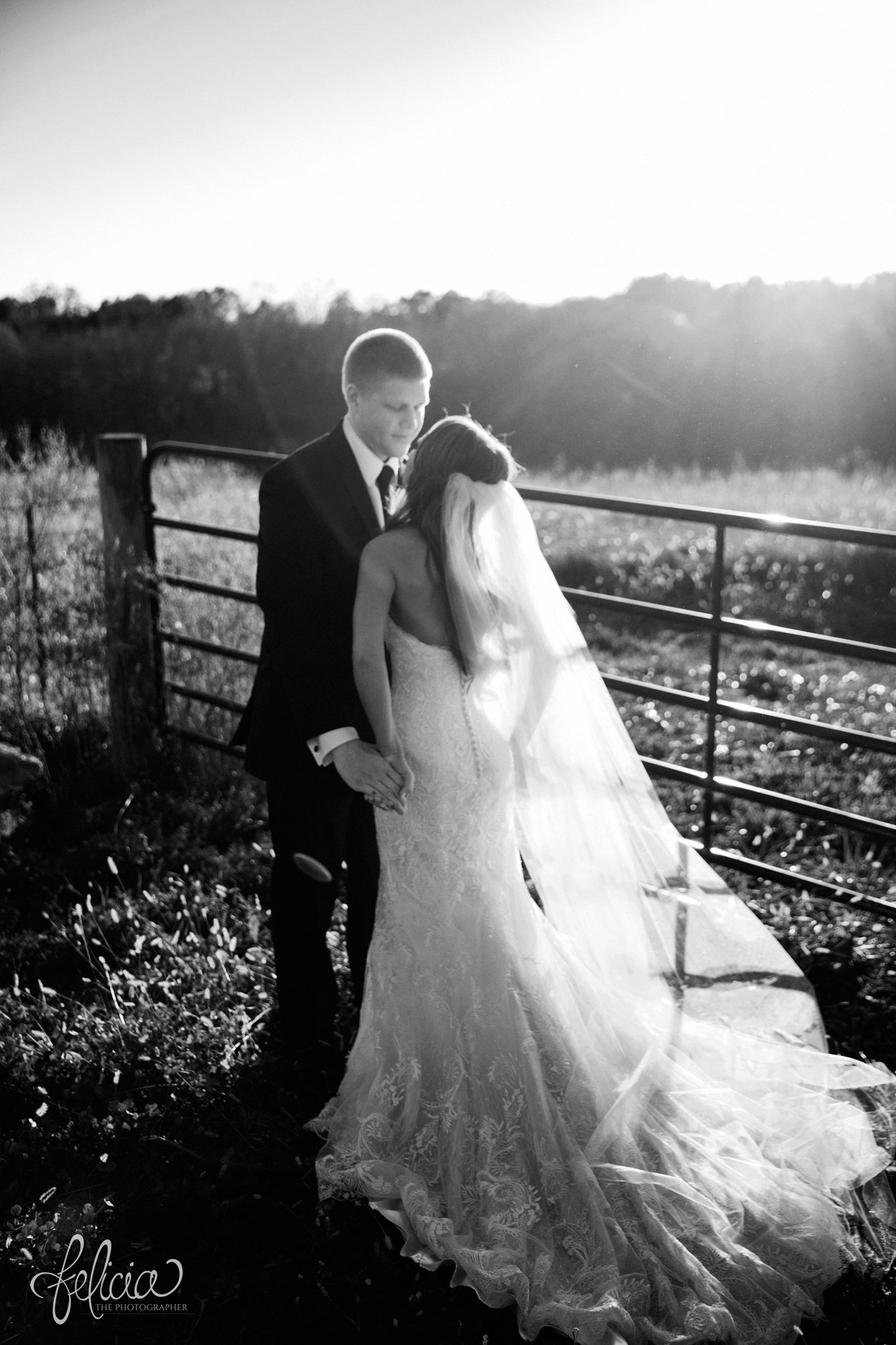 black and white | wedding | wedding photos | Rumely Event Space | wedding photography | images by feliciathephotographer.com | field background | nature | bride and groom portraits | sunlight | romantic sun | romance | sun flare | romantic pose | embrace | Wild Hill Flowers | fence 