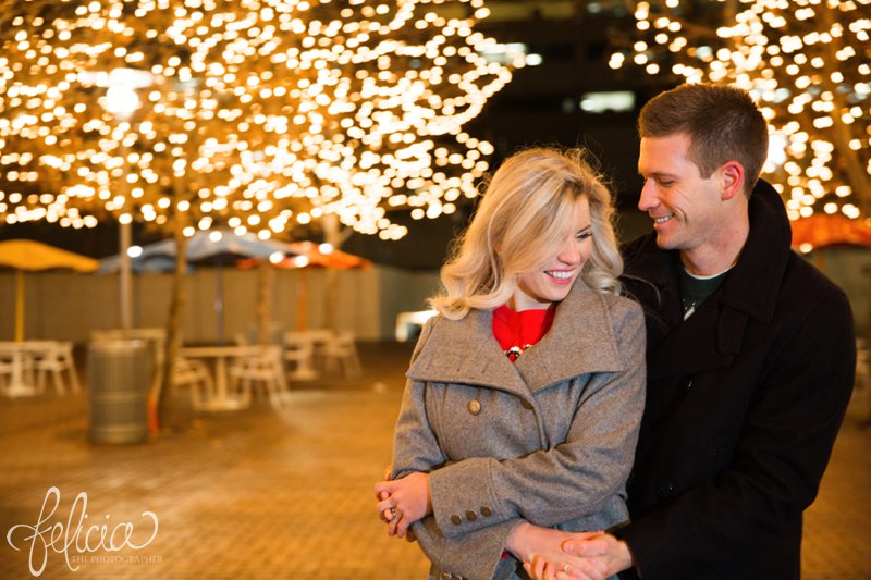 engagement photos | night engagement photos | Union Station | Kansas City | images by feliciathephotographer.com | romantic engagement | dramatic background | romantic poses | Christmas engagement photos | white lights | Christmas lights | dancing in the park | cuddling | candid smiling