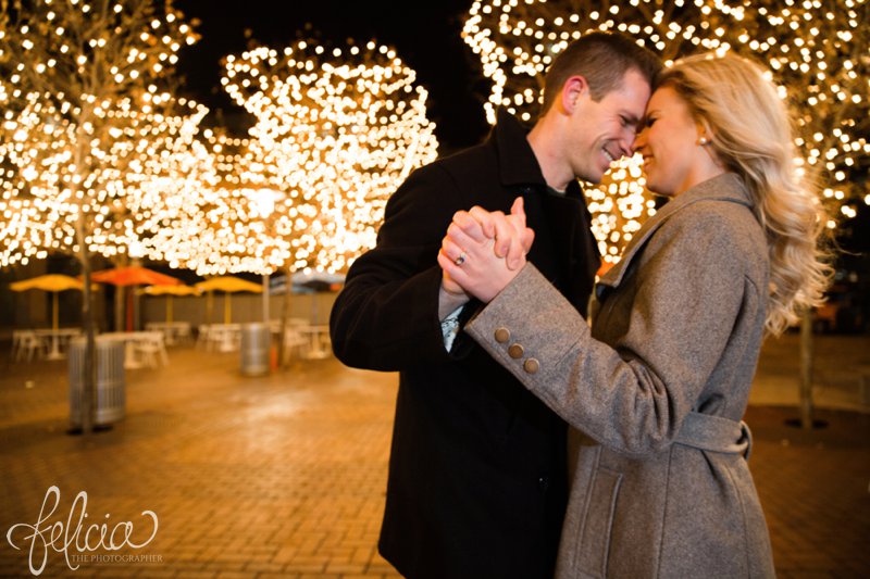 engagement photos | night engagement photos | Union Station | Kansas City | images by feliciathephotographer.com | romantic engagement | dramatic background | romantic poses | Old Hollywood | Christmas engagement photos | white lights | Christmas lights | dancing in the park | romantic pose | forehead touching | cobblestone | candid smiles | hand holding 