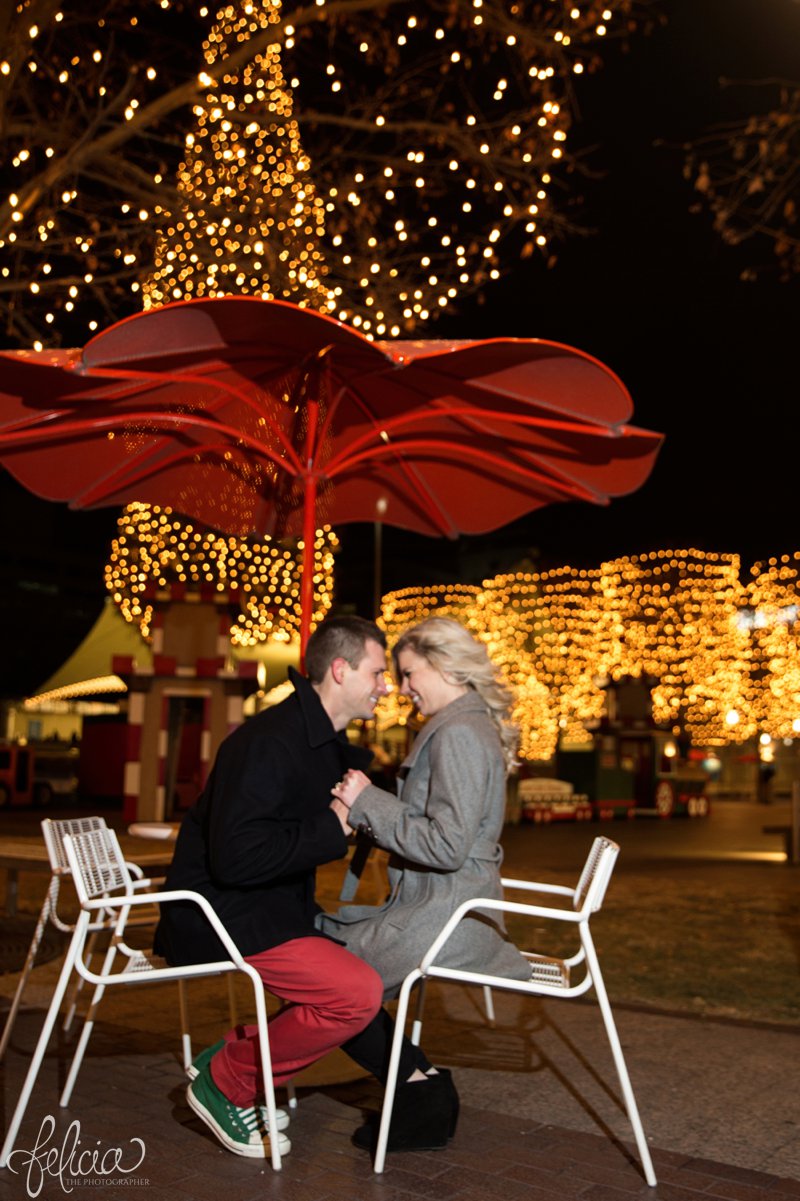 engagement photos | night engagement photos | Union Station | Kansas City | images by feliciathephotographer.com | romantic engagement | dramatic background | romantic poses | Christmas engagement photos | white lights | Christmas lights | dancing in the park | romantic pose | forehead touching | cobblestone | candid smiles | hand holding 