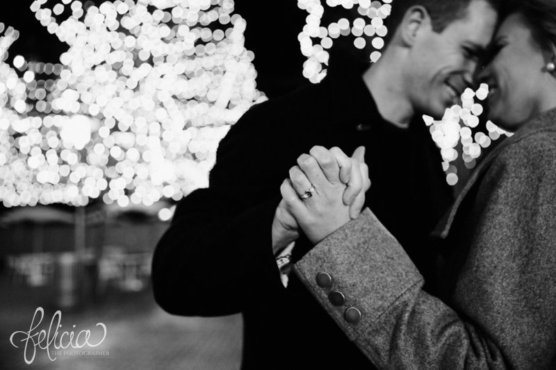 black and white | engagement photos | night engagement photos | Union Station | Kansas City | images by feliciathephotographer.com | romantic engagement | dramatic background | romantic poses | Old Hollywood | Christmas engagement photos | white lights | Christmas lights | dancing in the park | romantic pose | forehead touching | cobblestone | candid | hand holding 