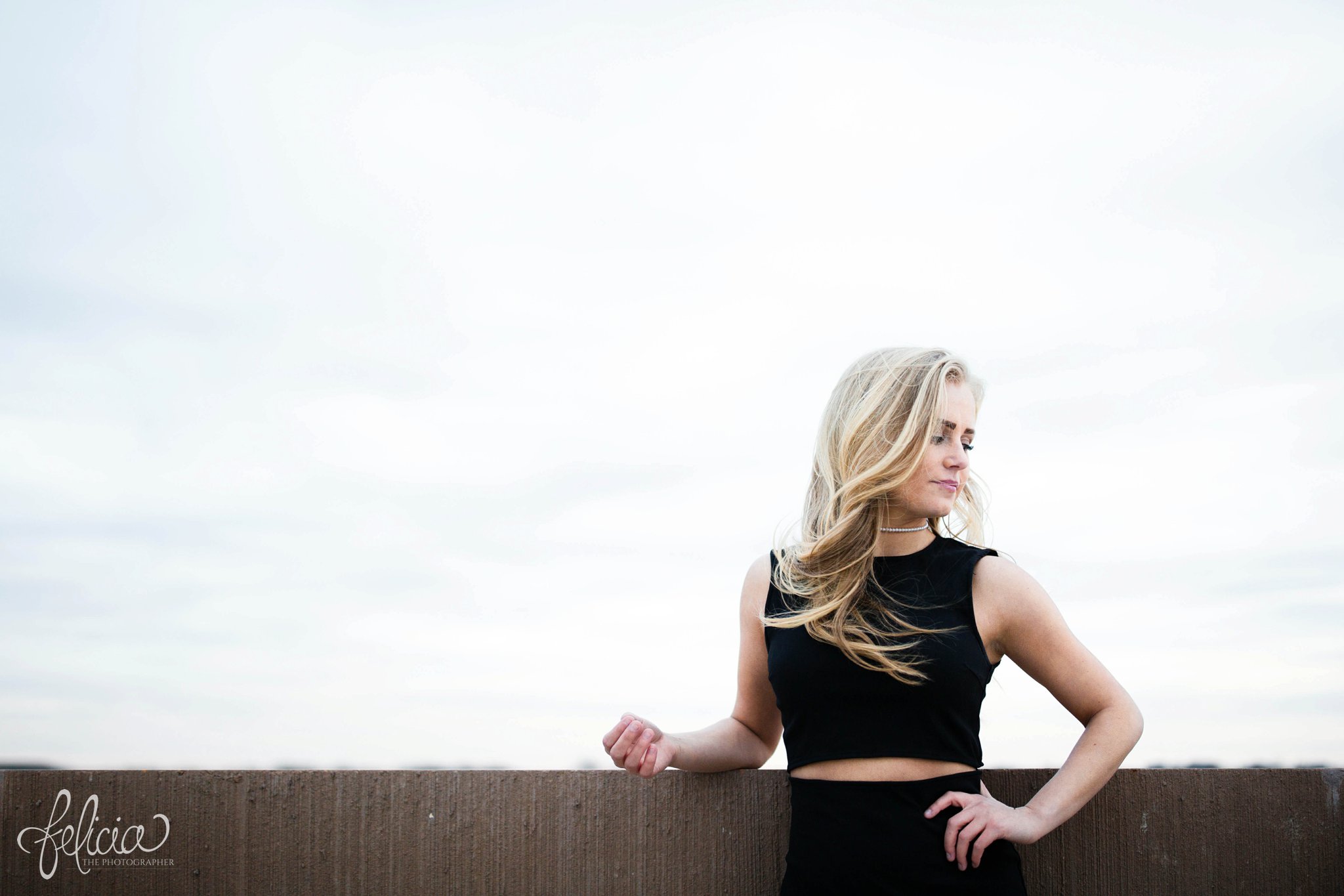 senior photos | senior photography | Lenexa | Kansas | images by feliciathephotographer.com | chic | dancer  | long blonde hair | hair flip | pearl jewelry | pearl necklace | pearl earrings | black outfit | dramatic pose | hand on hip | looking down  