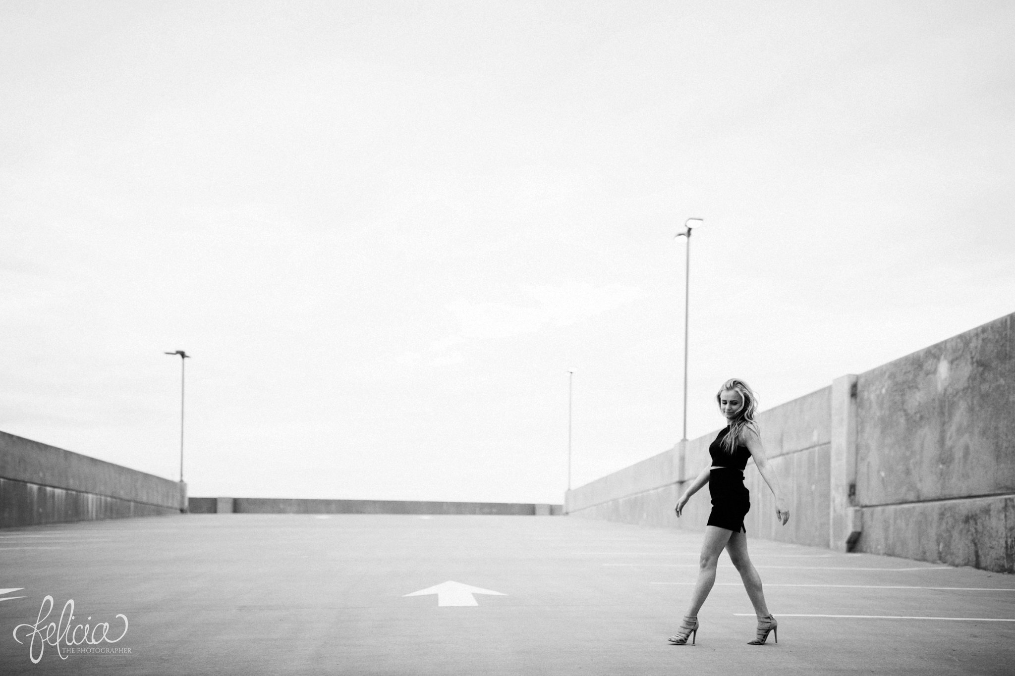 black and white | senior photos | senior photography | Lenexa | Kansas | images by feliciathephotographer.com | chic | dancer  | long blonde hair | hair flip | pearl jewelry | pearl necklace | pearl earrings | black outfit | dramatic pose | dramatic | elegant | model walk | high heels | rustic | parking lot photos   