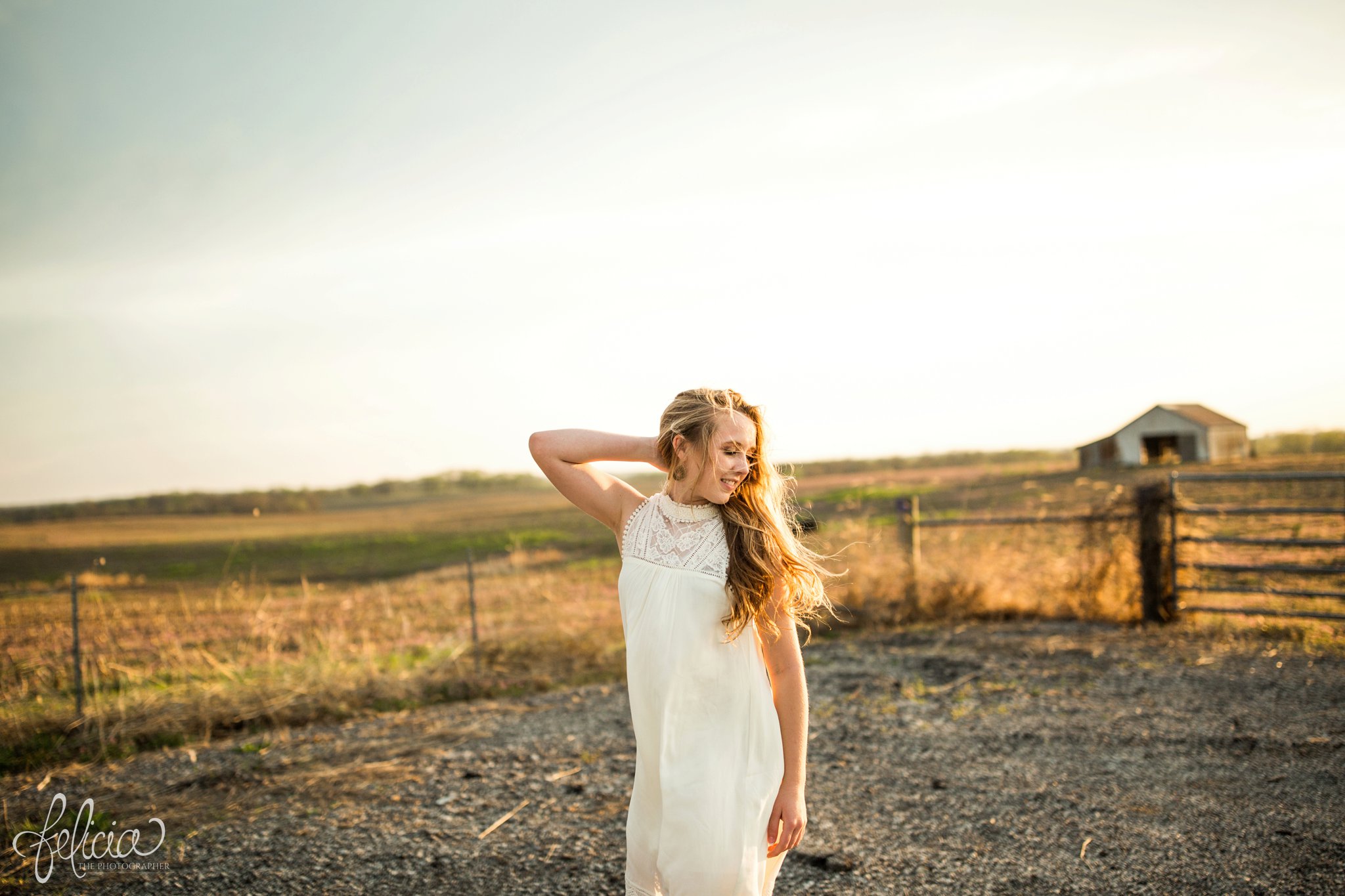 senior pictures | images by feliciathephotographer.com | Kansas City | rustic | long blonde hair | nature background | farm house | white dress | elegant | dramatic pose | farm pictures