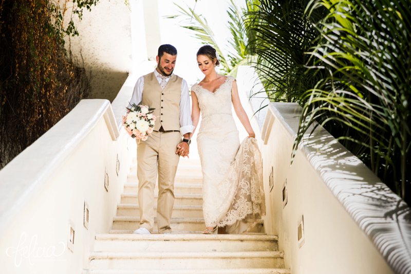 images by feliciathephotographer.com | Destination Beach Wedding | Mexico Resort | Photography | Azul Sensatori | staircase | holding hands | lace dress train | pastel bouquet | green | palm trees | bride and groom | v neck | tan suit | floral tie 