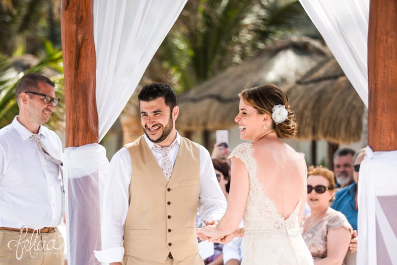 images by feliciathephotographer.com | Destination Beach Wedding | Mexico Resort | Photography | Azul Sensatori | bride | groom | ceremony | floral tie | tan suit | lace dress | open back | beading | up-do | exchanging rings | laughter | joy | sentimental | 