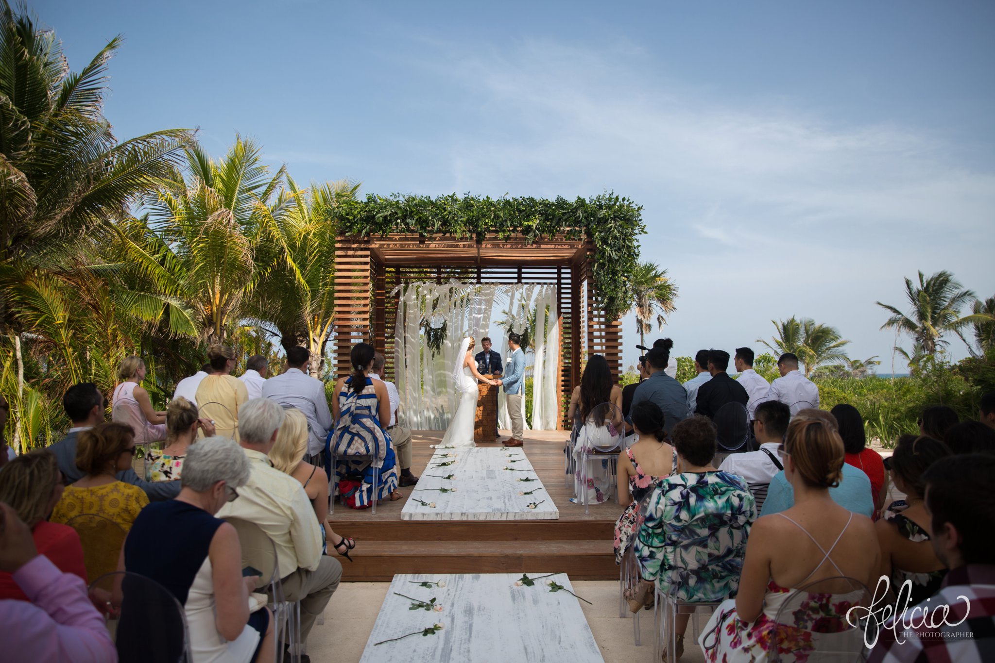 images by feliciathephotographer.com | Destination Beach Wedding | Unicco 20 87 | Photographer | L&S Travel | ceremony | marriage | ocean view | blue sky | wooden gazebo | palm trees | green | bride | groom | holding hands | symmetry | 