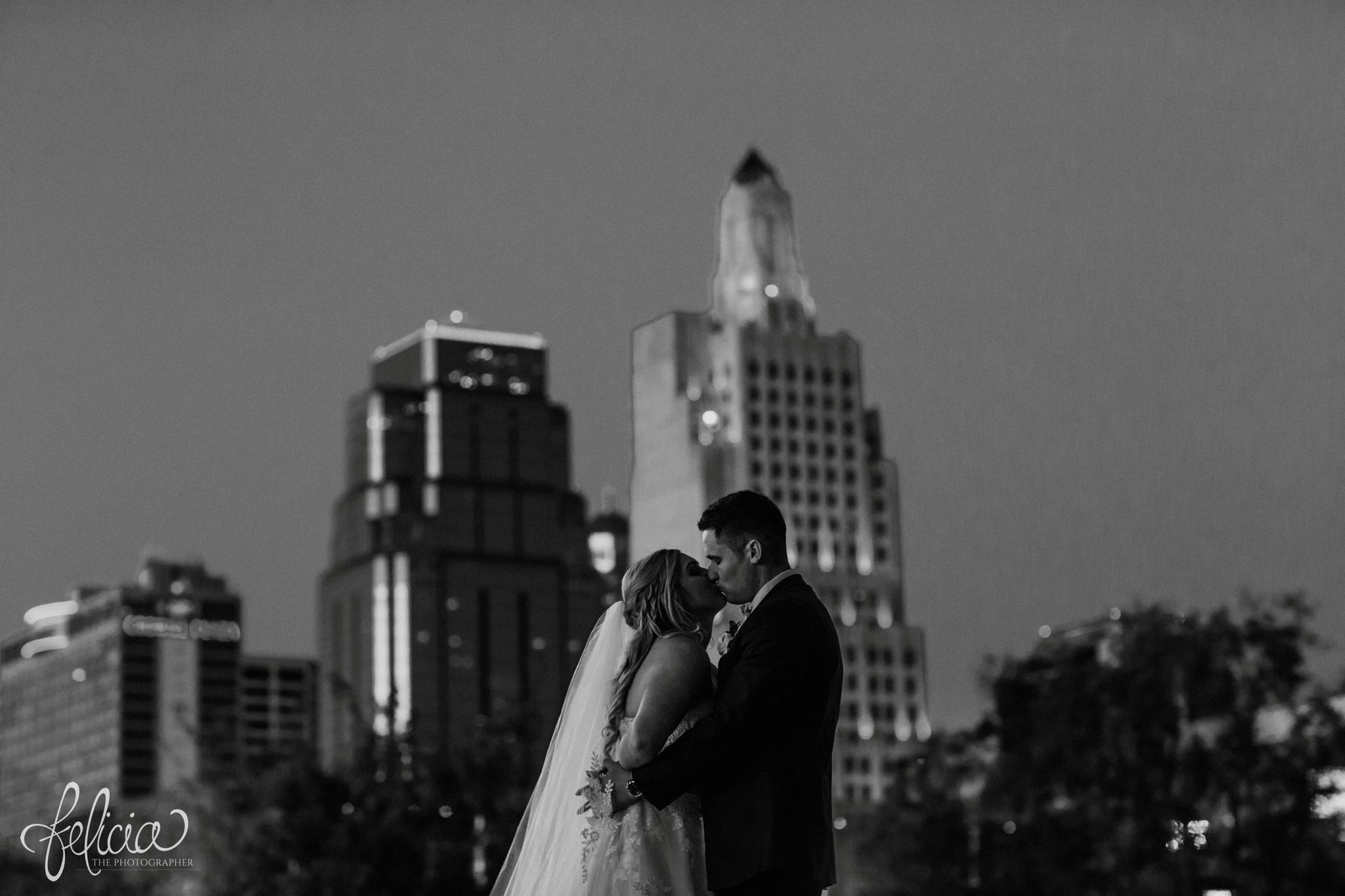 images by feliciathephotographer.com | wedding photographer | downtown kansas city | bride and groom portrait | black and white | kiss | skyline | nighttime | romantic | glamorous | 