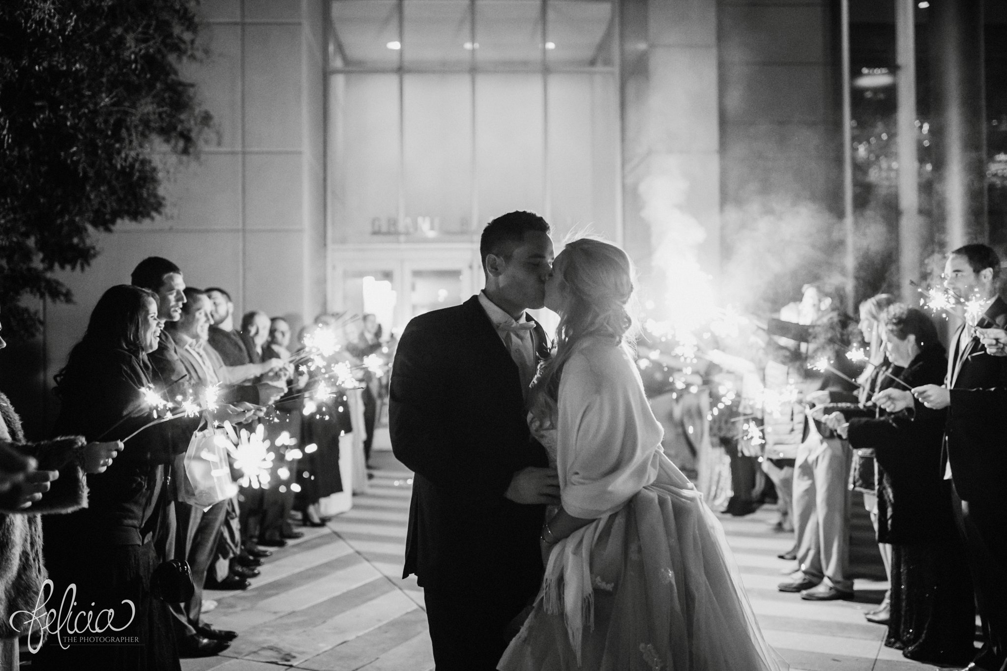 images by feliciathephotographer.com | wedding photographer | downtown kansas city | grand exit | sparklers | celebration | kc convention center | glamorous | lace tiered dress | family and friends | kiss | black and white | 