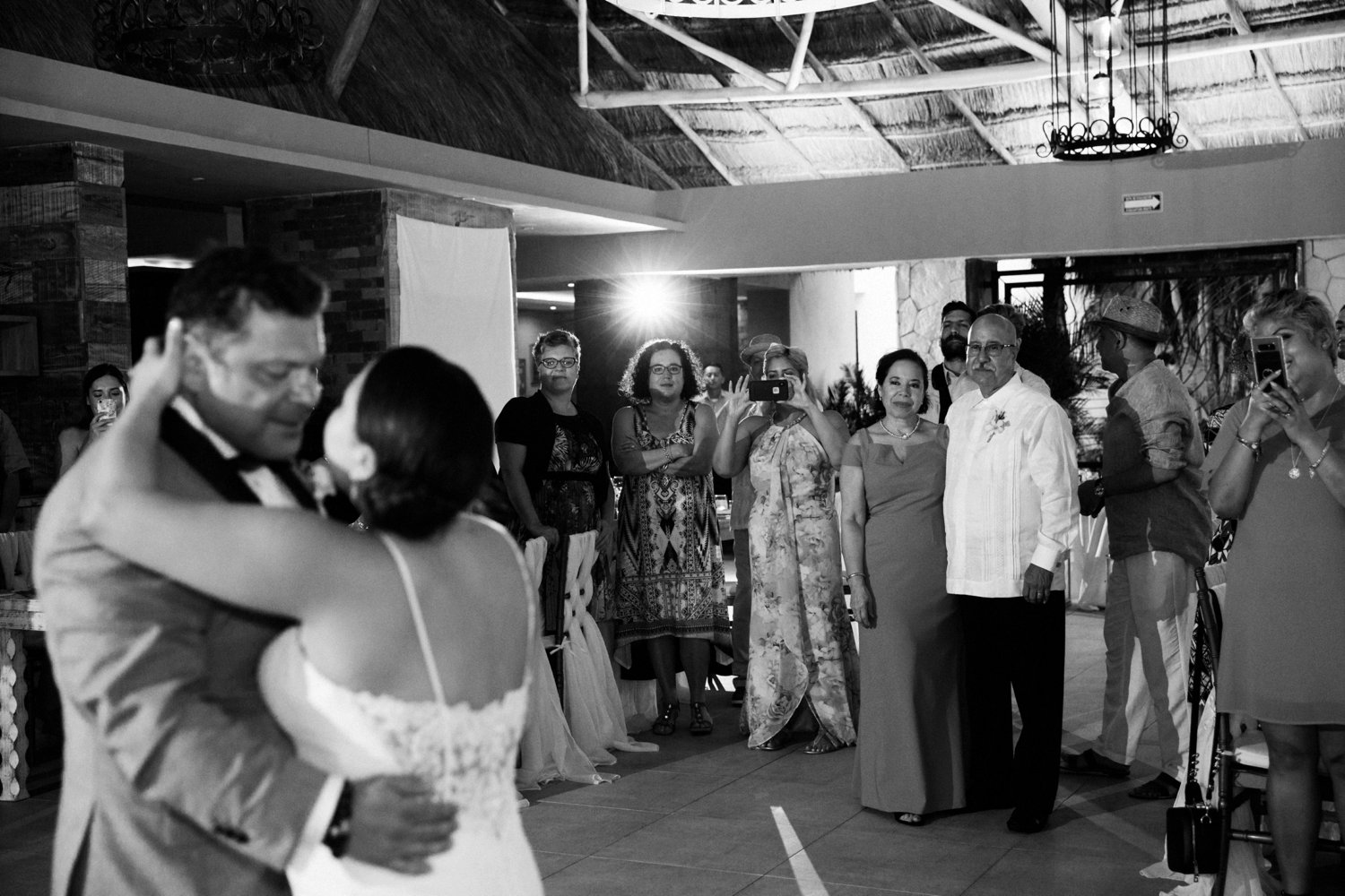  images by feliciathephotographer.com | destination wedding photographer | mexico | tropical | fiji | venue | azul beach resort | riviera maya | reception | first dance | white chandelier | long lace dress | grey suit | romantic | black and white | 