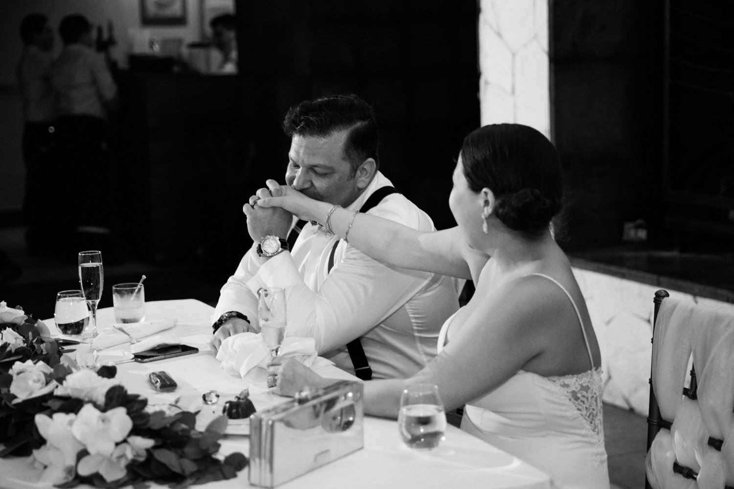  images by feliciathephotographer.com | destination wedding photographer | mexico | tropical | fiji | venue | azul beach resort | riviera maya | reception | dinner | formal setting | bride and groom | head table | black and white | kiss on the hand | 