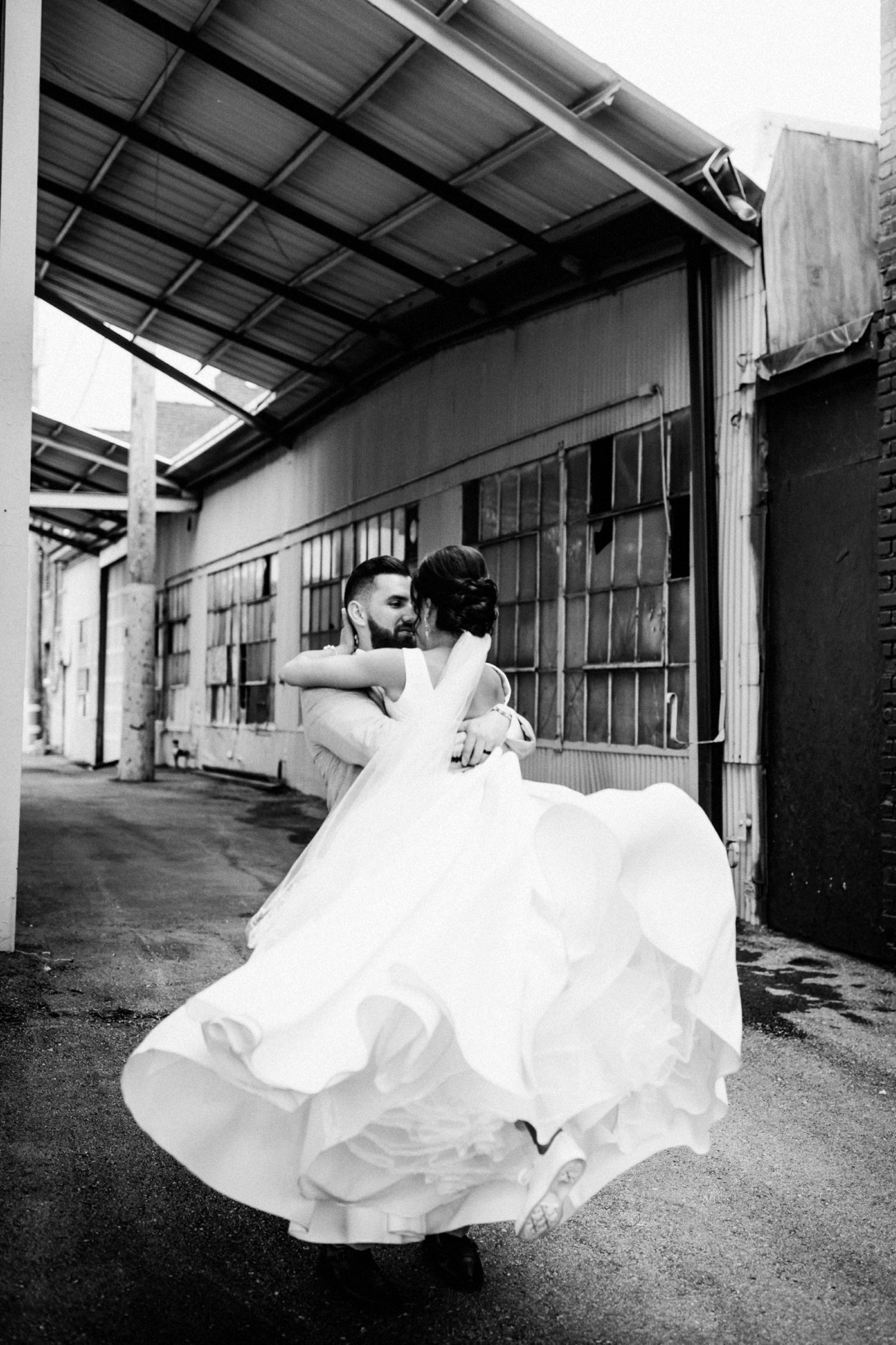  images by feliciathephotographer.com | destination wedding photographer | kansas city | spring time | couple portraits | white a line gown | david's bridal | grey suit | the black tux | up do | kiss | true love | industrial | modern | pearl bracelet | diamond teardrop earrings | black and white | jared | twirl | 