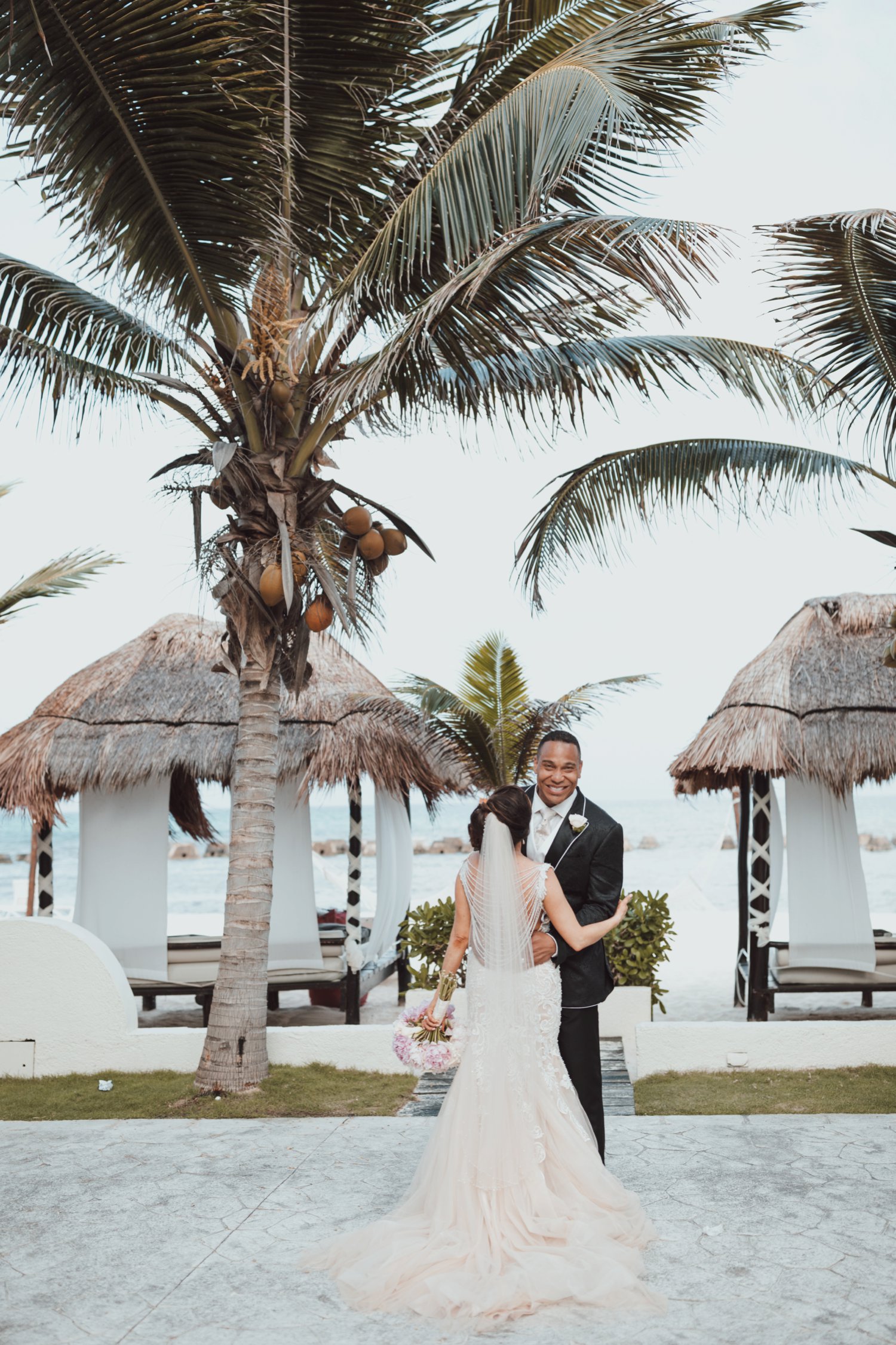  images by feliciathephotographer.com | destination wedding photographer | el dorado riviera maya | glamorous | beachside | resort | couple portraits | bride and groom | beaded draped back gown | allure | palm trees | tropical | cabanas | the black tux | white and pink bouquet | 
