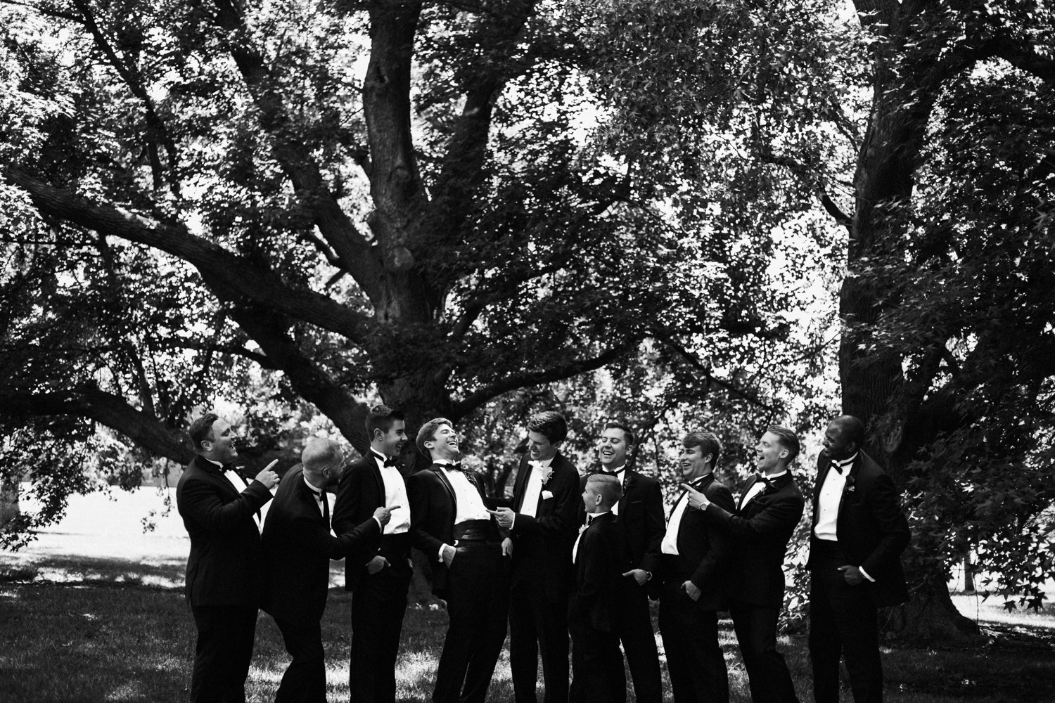  images by feliciathephotographer.com | destination wedding photographer | kansas city | summertime | classic | groomsmen portrait | black and white | loose park | contrast | nature | tuxedo | mens warehouse | ring barrier | laughter | silly | 
