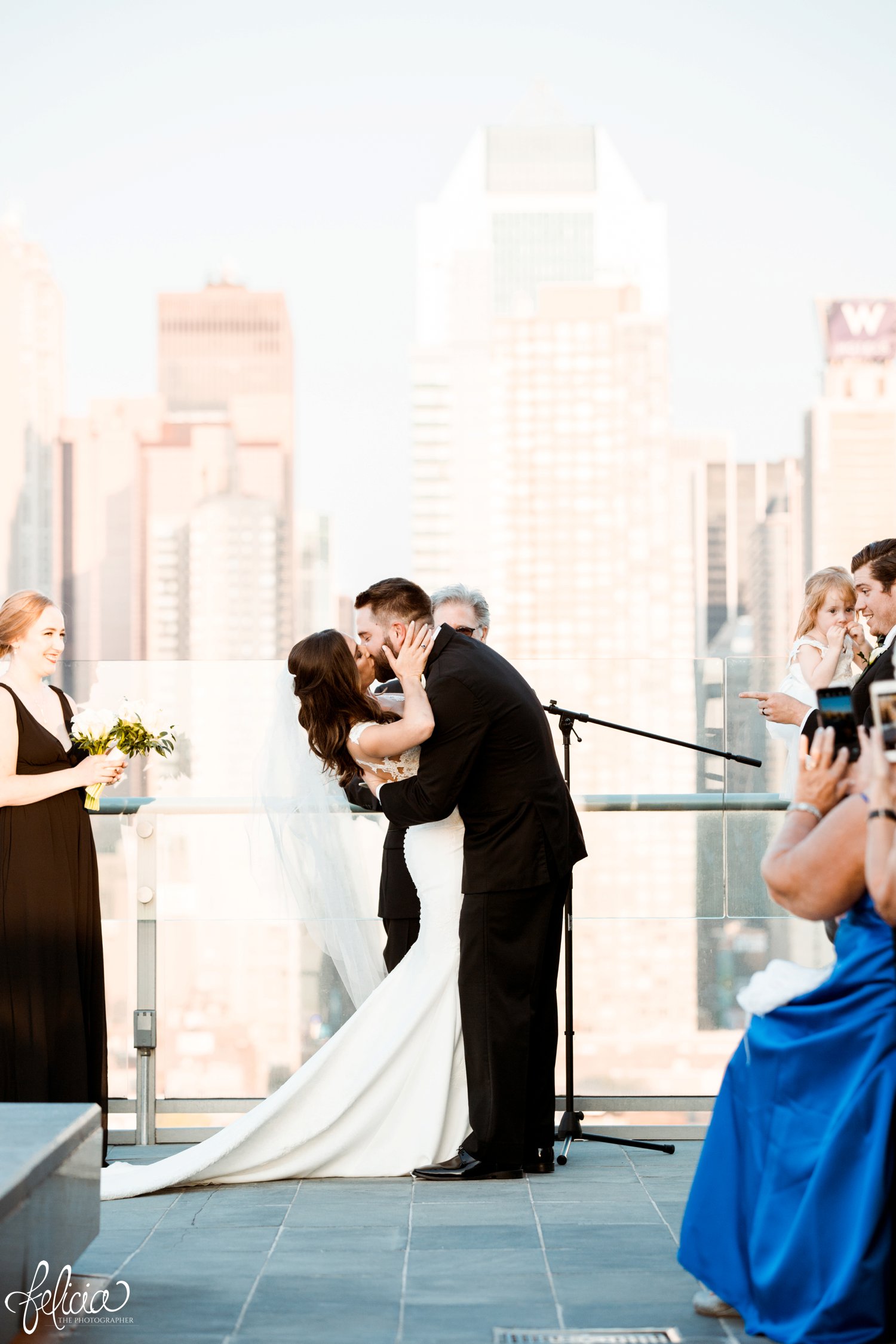 images by feliciathephotographer.com | destination wedding photographer | new york city | ceremony | rooftop | skyline | urban | romantic | classic | emotional | bride and groom | long white gown | lace details | open back | black tuxedo | mens warehouse | pronovais | nordstrom | first kiss | 