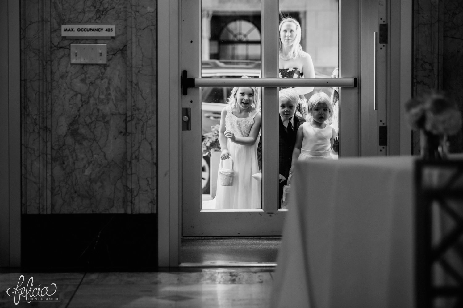 images by feliciathephotographer.com | destination wedding photographer | the grand hall at power and light | kansas city | missouri | downtown | glamorous | multicultural | ceremony | black and white | flower girl | ring barrier | 