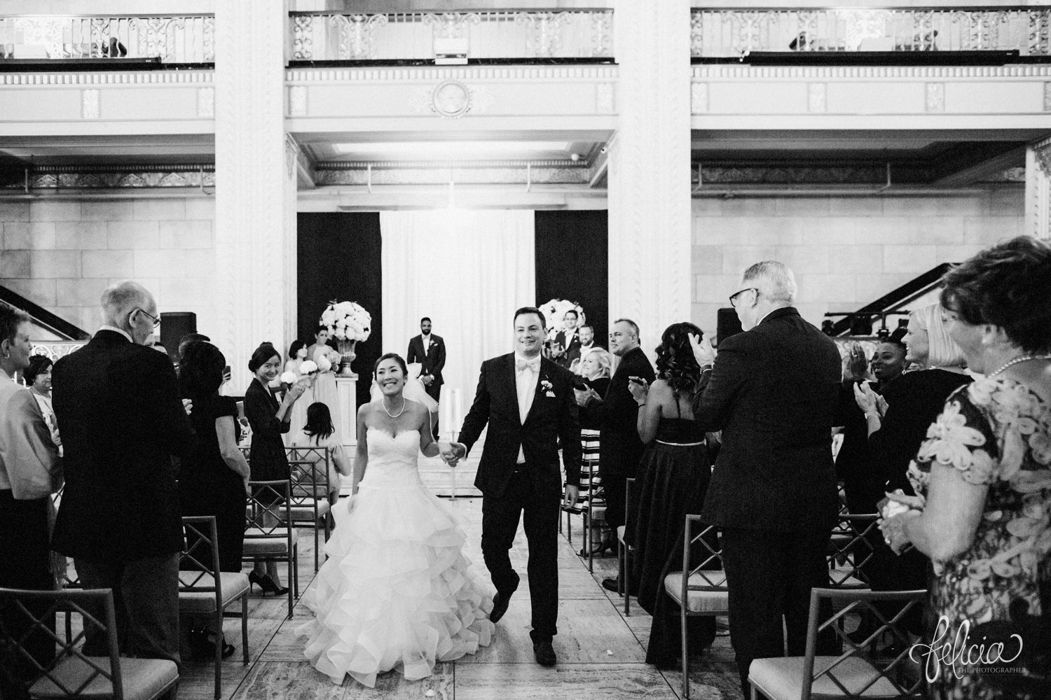 images by feliciathephotographer.com | destination wedding photographer | the grand hall at power and light | kansas city | missouri | downtown | glamorous | multicultural | ceremony | details | black and white | walking down the aisle | posh bridal | mr and mrs | 