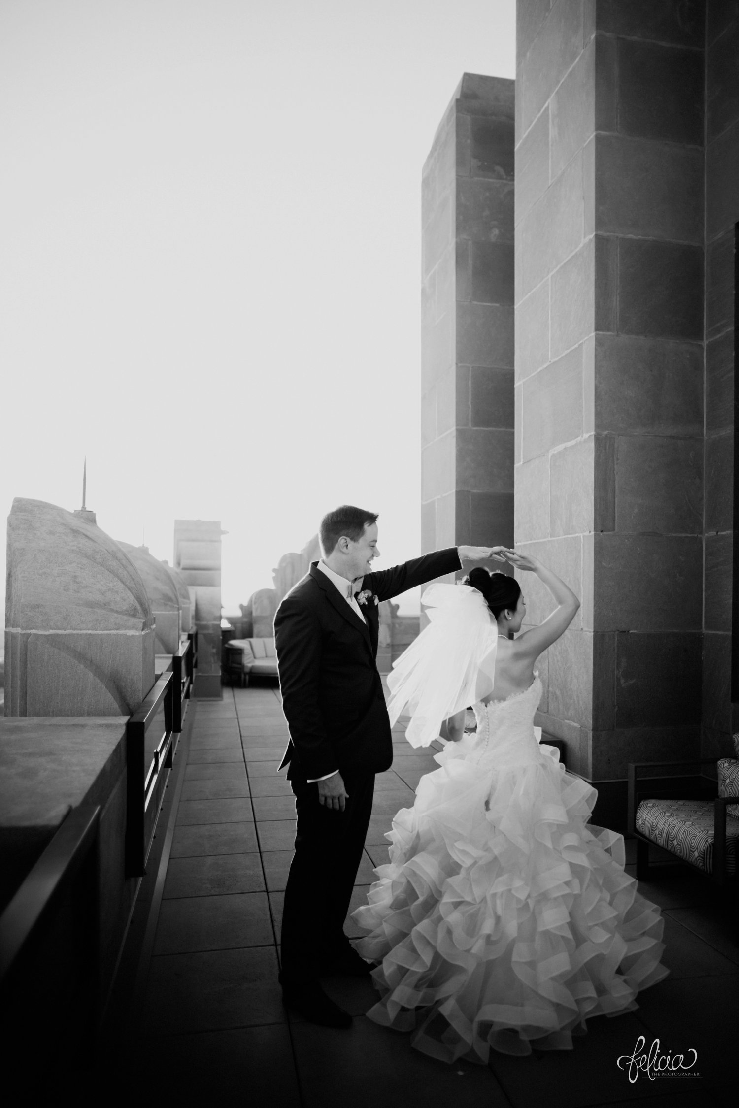 images by feliciathephotographer.com | destination wedding photographer | the grand hall at power and light | kansas city | missouri | downtown | glamorous | multicultural | black and white | couple portrait | dramatic lighting | sunset | golden hour | twirl | dance | 