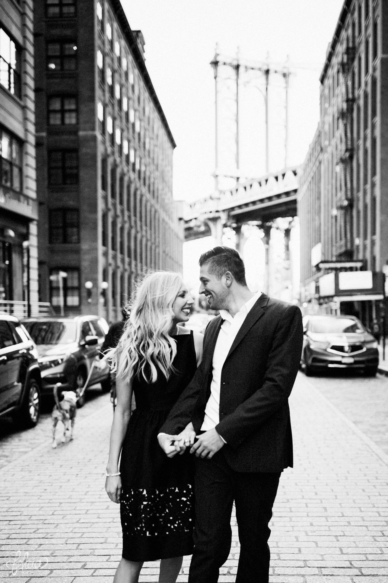images by feliciathephotographer.com | destination wedding photographer | engagement | new york city | brooklyn bridge | skyline | formal | classic | true love | romantic | cuddles | pearls | diamond ring | urban | joyful | middle of the street | black and white | cuddles | 