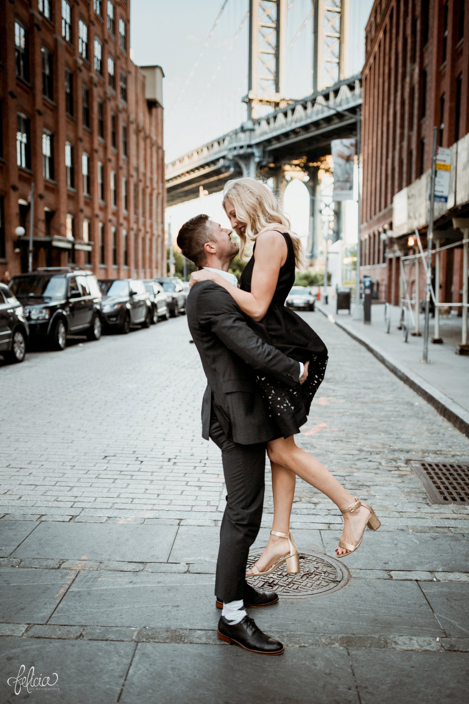 images by feliciathephotographer.com | destination wedding photographer | engagement | new york city | brooklyn bridge | skyline | formal | classic | true love | romantic | cuddles | pearls | diamond ring | urban | joyful | middle of the street | little black dress | 